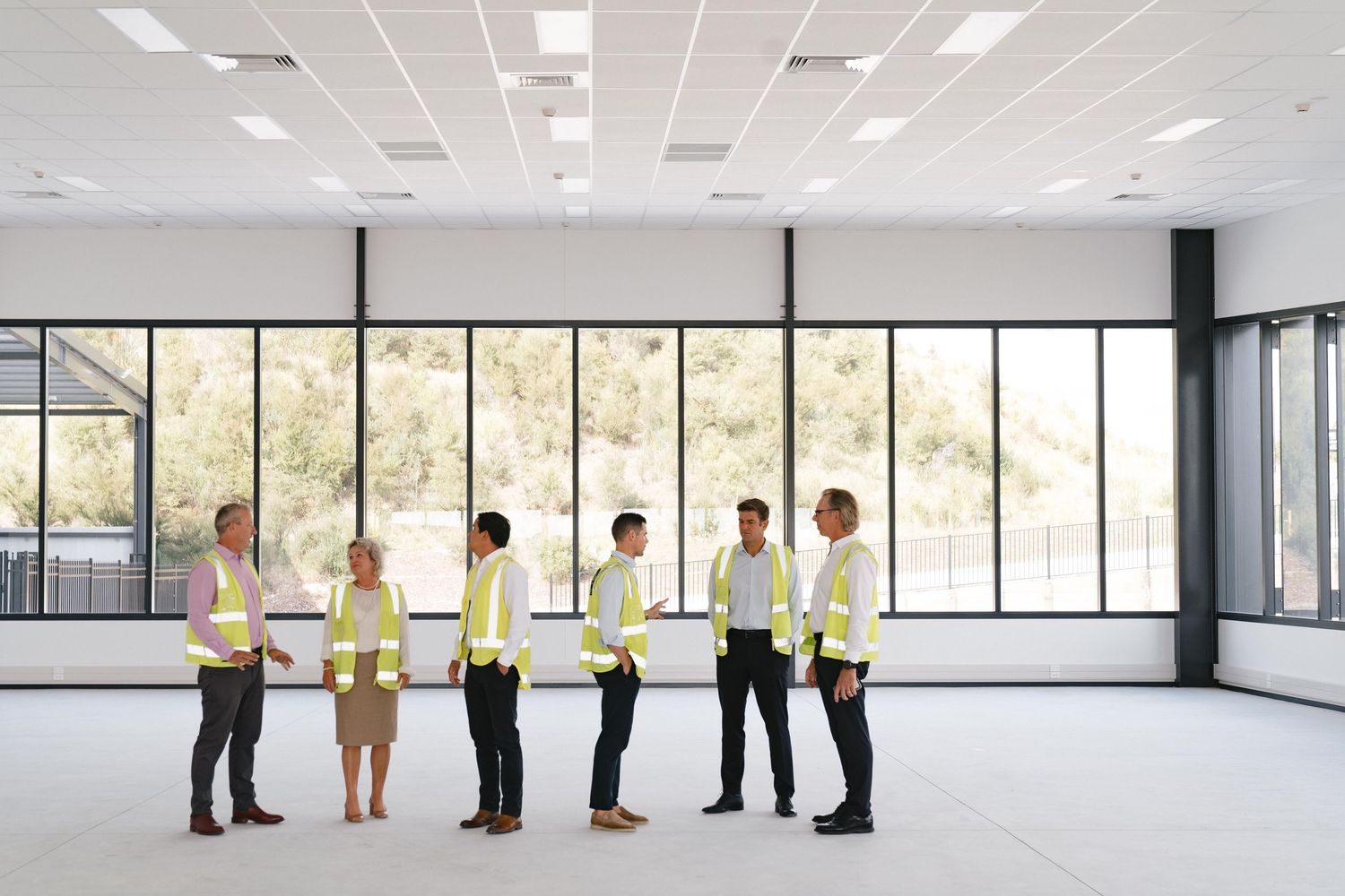 Business professionals meeting in a bright, spacious office with large windows.