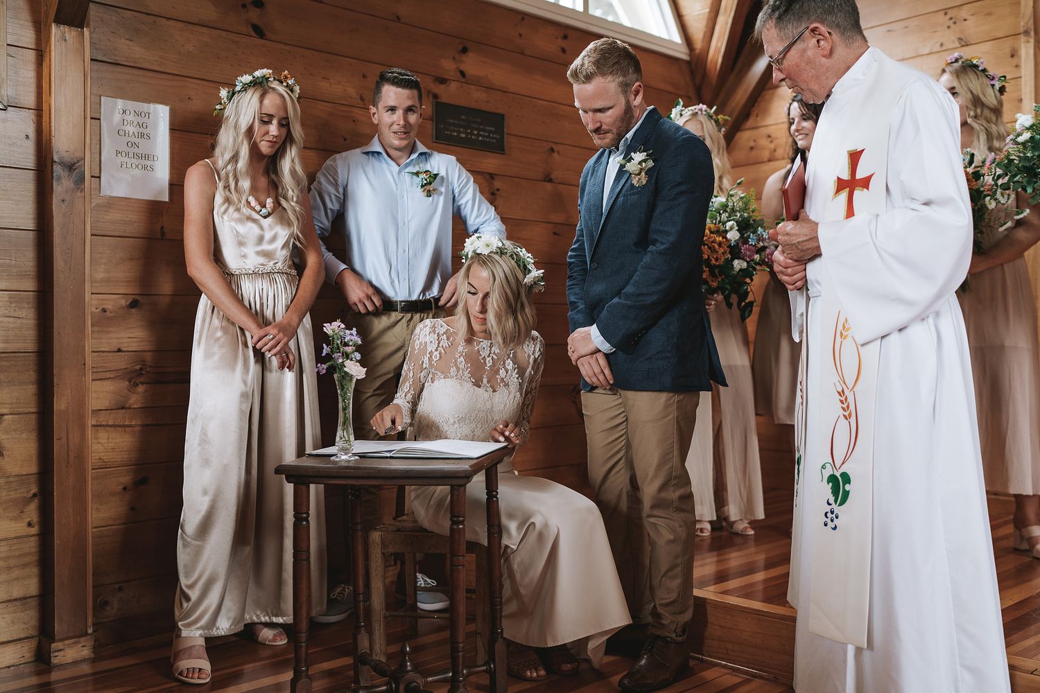 Wedding party celebrates in rustic wooden barn with string lights and natural decor creating a warm atmosphere.