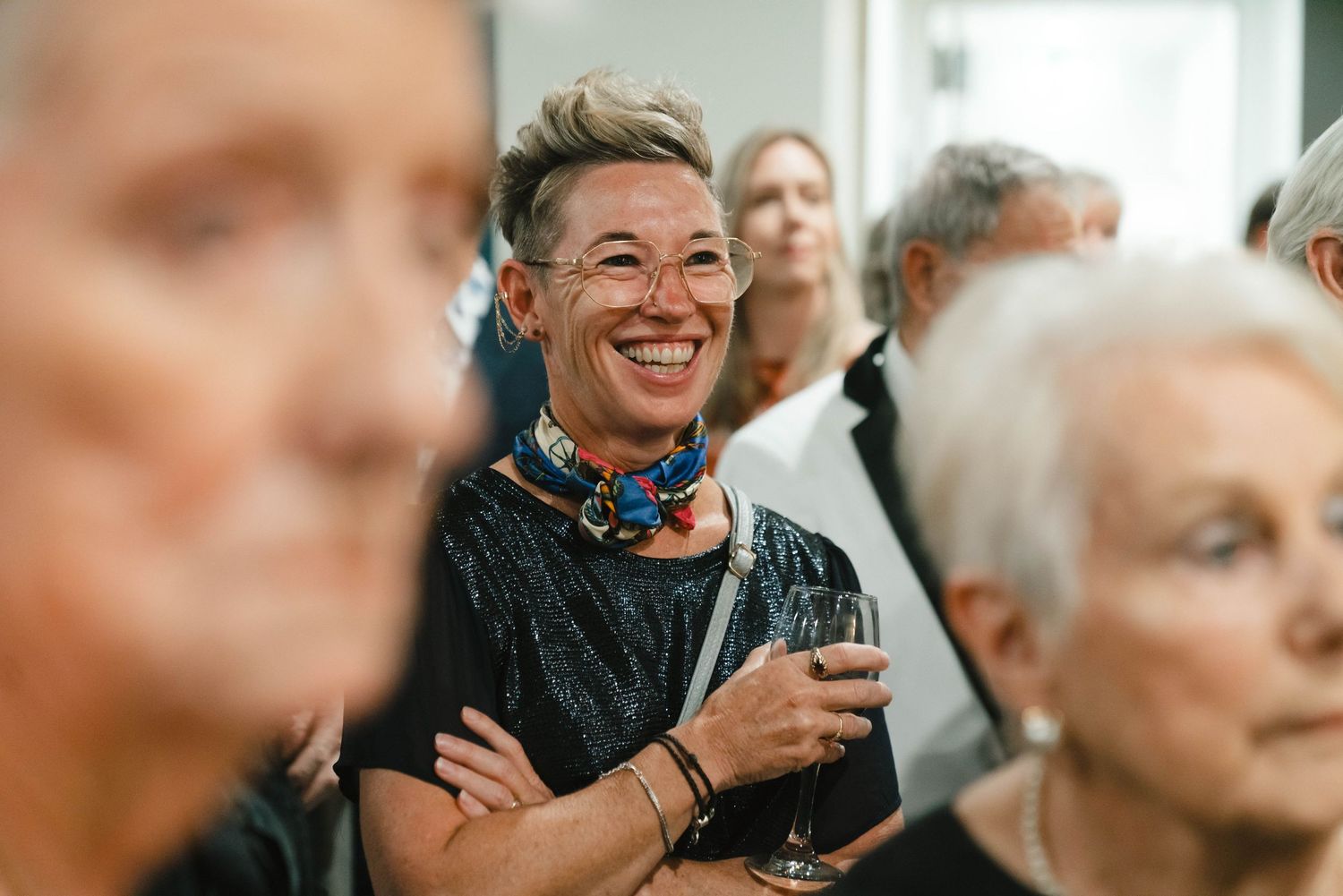 Group of guests socializing and laughing at an evening event.