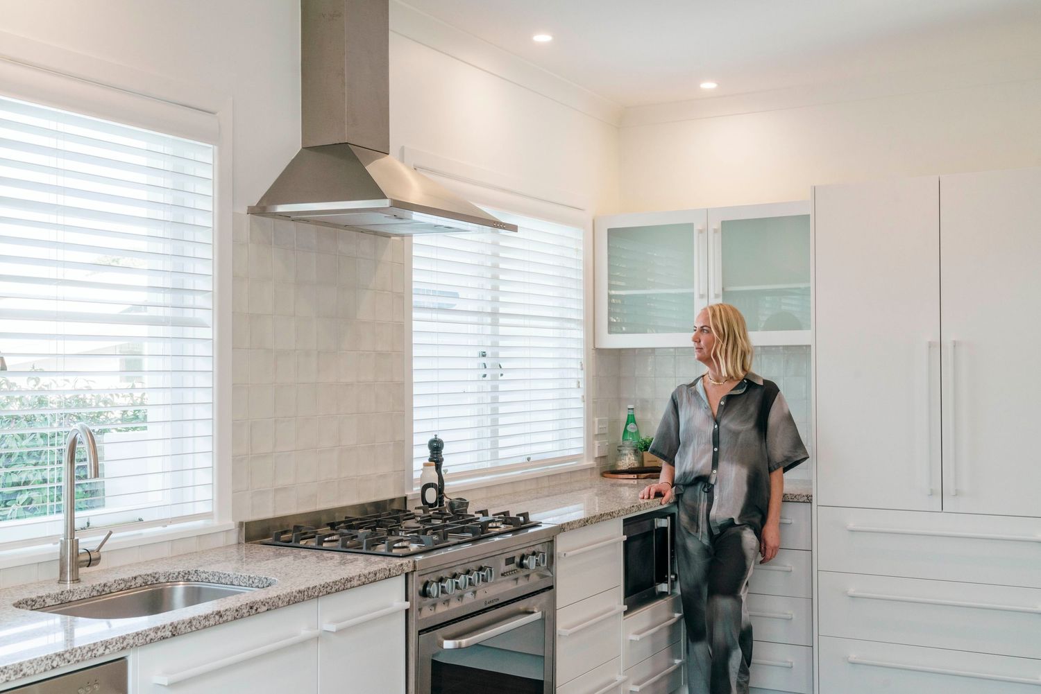 Contemporary white kitchen with stainless steel appliances and granite countertops.
