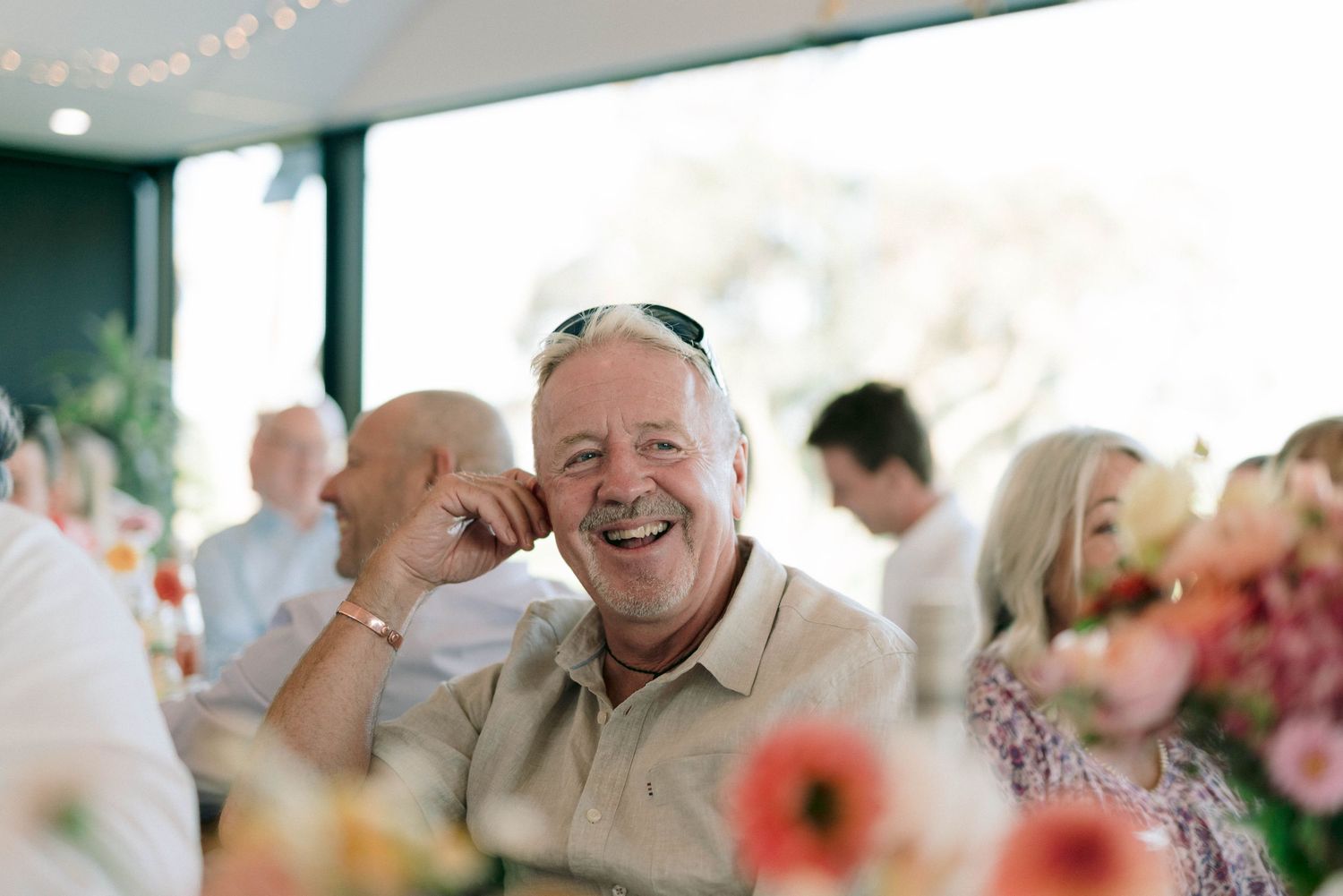 Wedding guest enjoys a lively moment during outdoor reception with floral decorations.