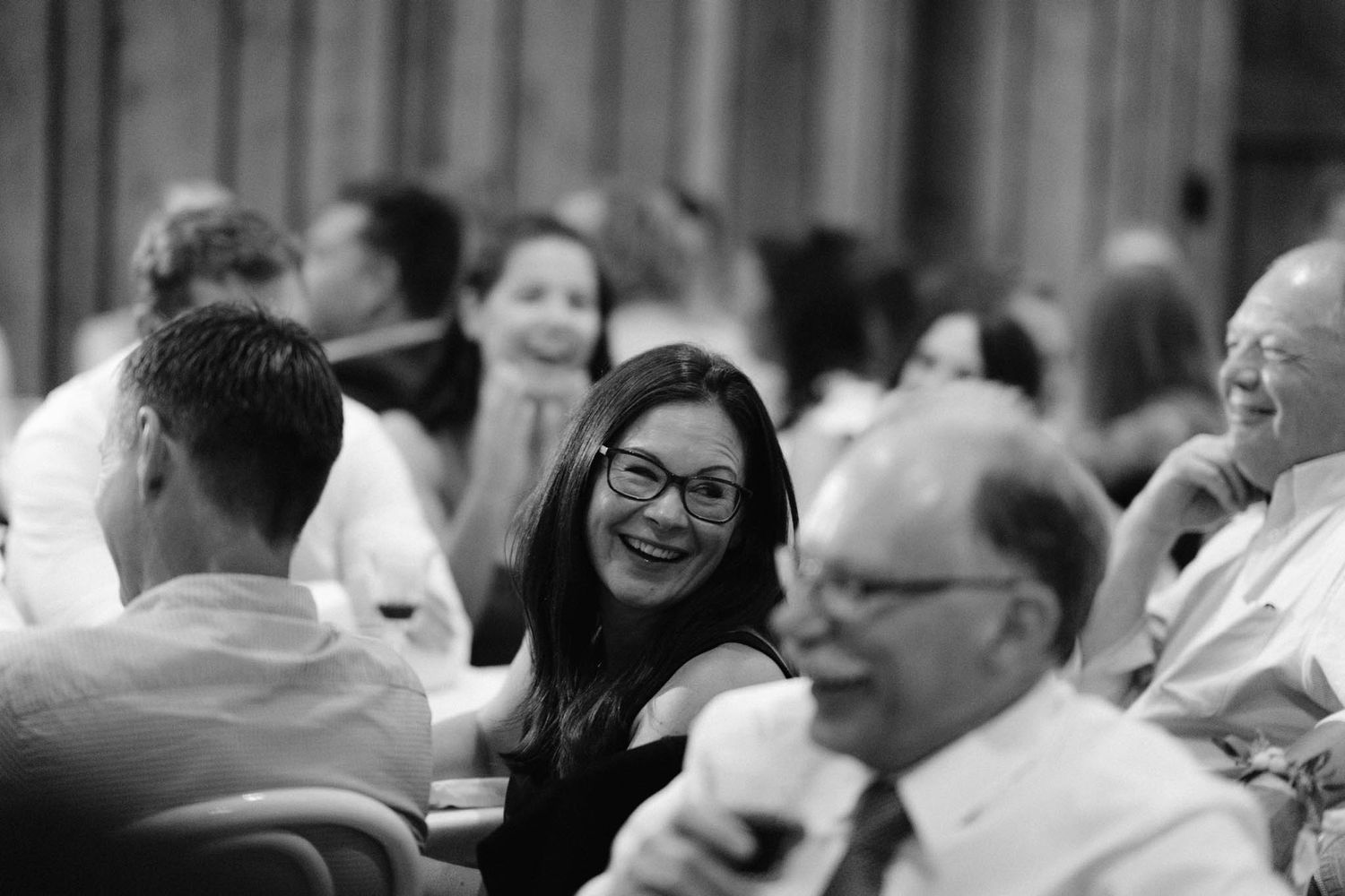 A crowd of business professionals engaged in animated conversation at a networking event.