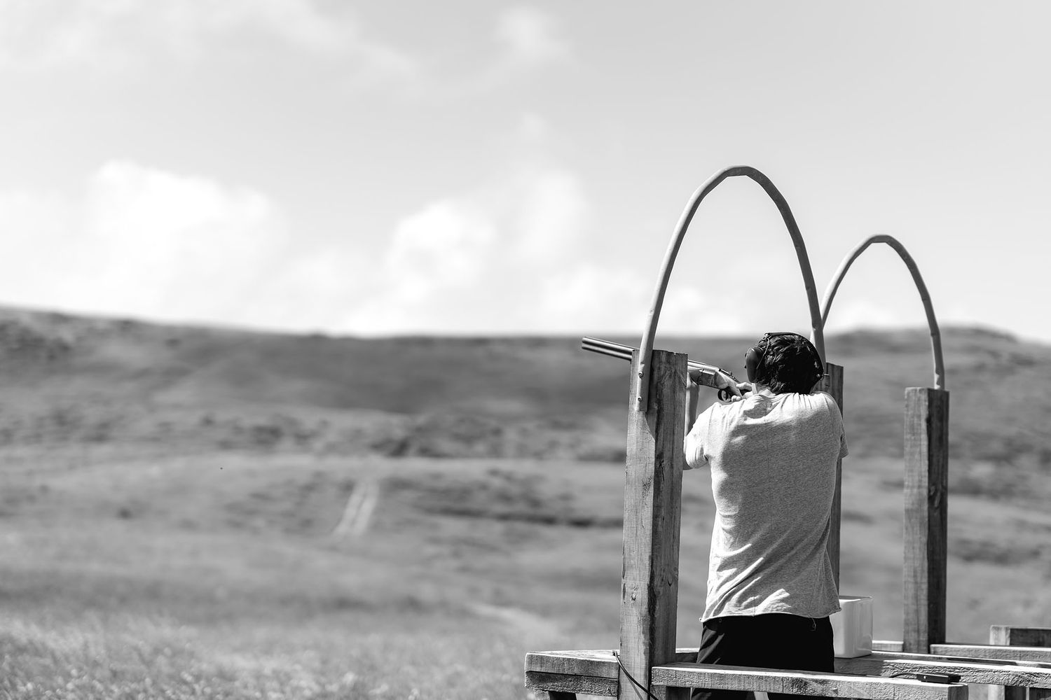 A black and white image sequence showing a mailbox being opened and closed in a rural setting against a cloudy sky.