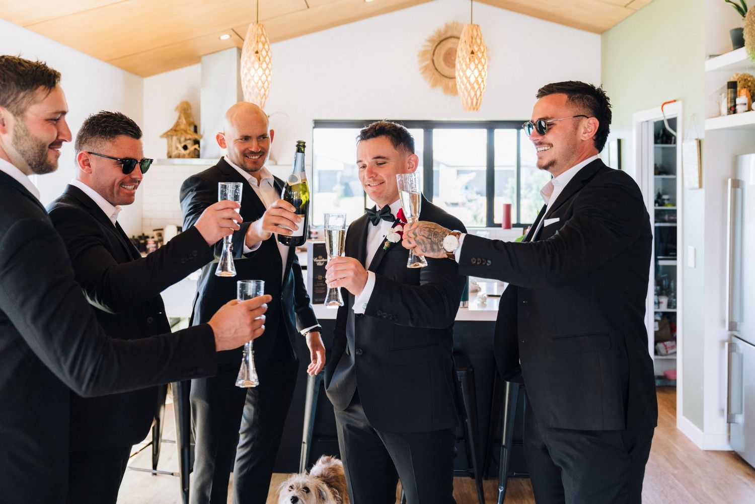 A group in formal attire toasting with champagne glasses in an indoor celebration.