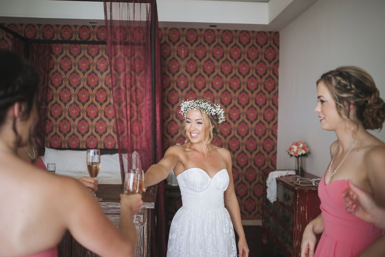Wedding preparation scene in room with red damask wallpaper.