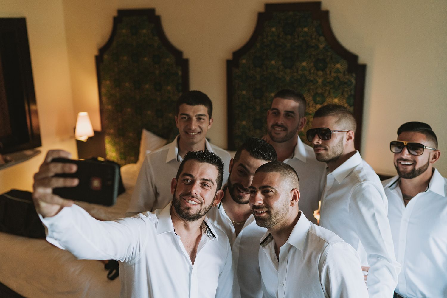 A group in white shirts takes a selfie together during a social gathering.
