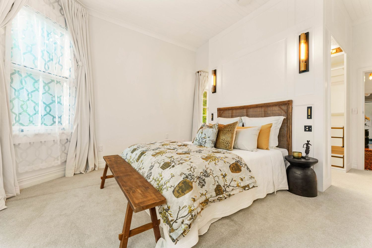 Bright, airy bedroom with white linens, natural light, and floral accents.