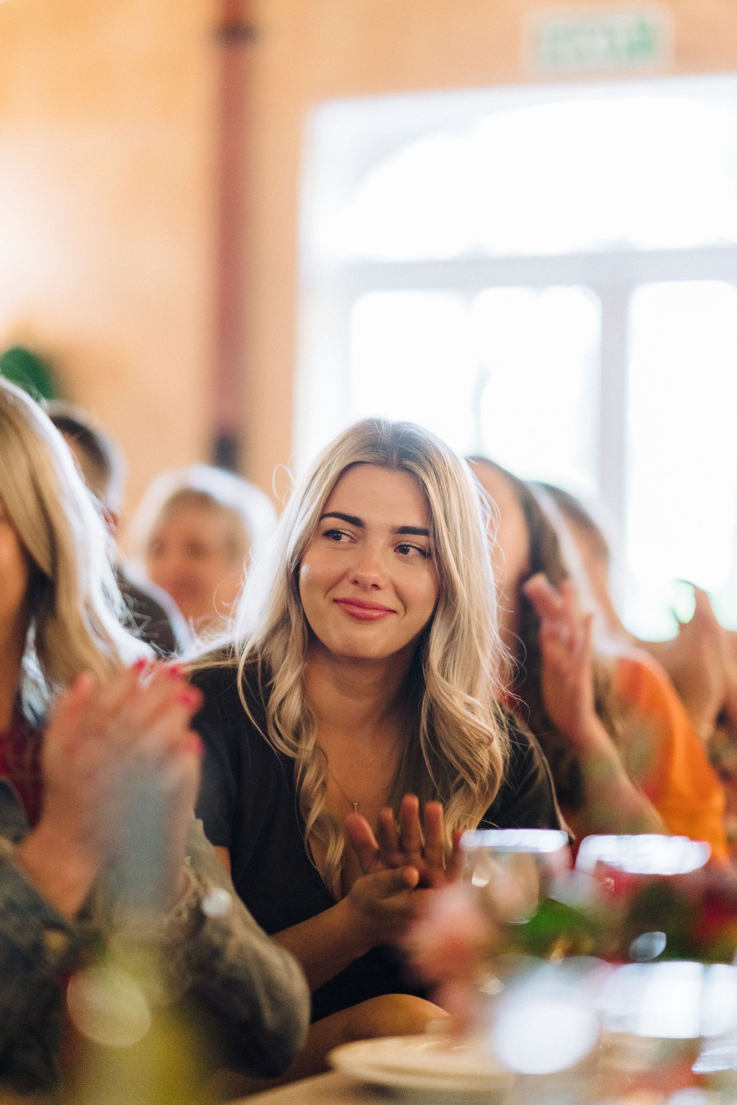 A candid moment captured during a wedding reception showing guests engaging in conversation.