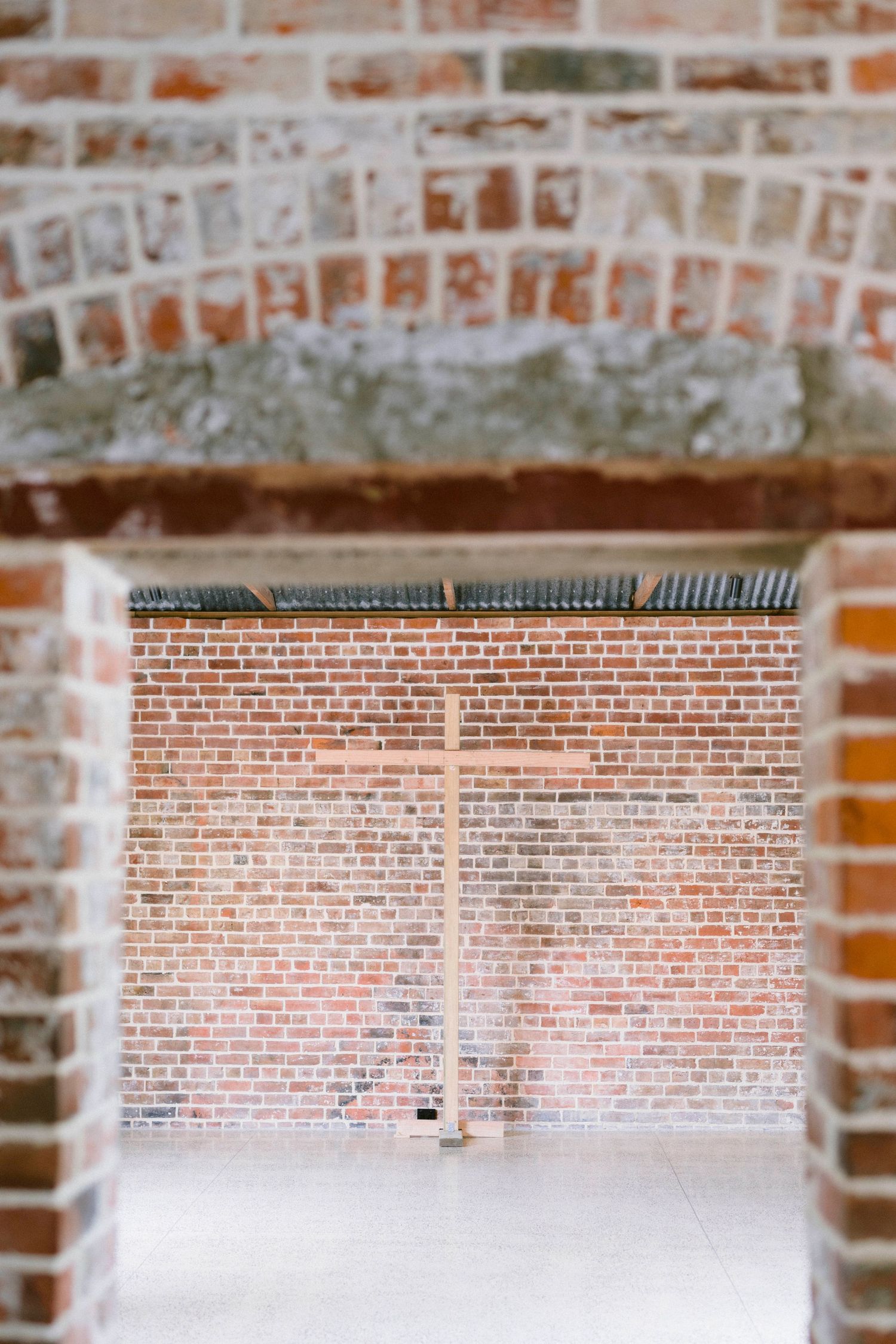 Wedding ceremony program details displayed on rustic exposed brick wall at venue.