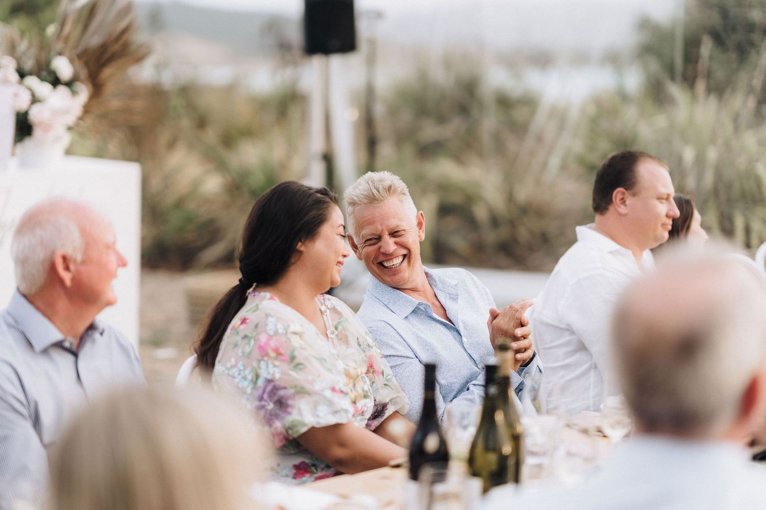 Wedding guests enjoying conversation and drinks at an outdoor reception.