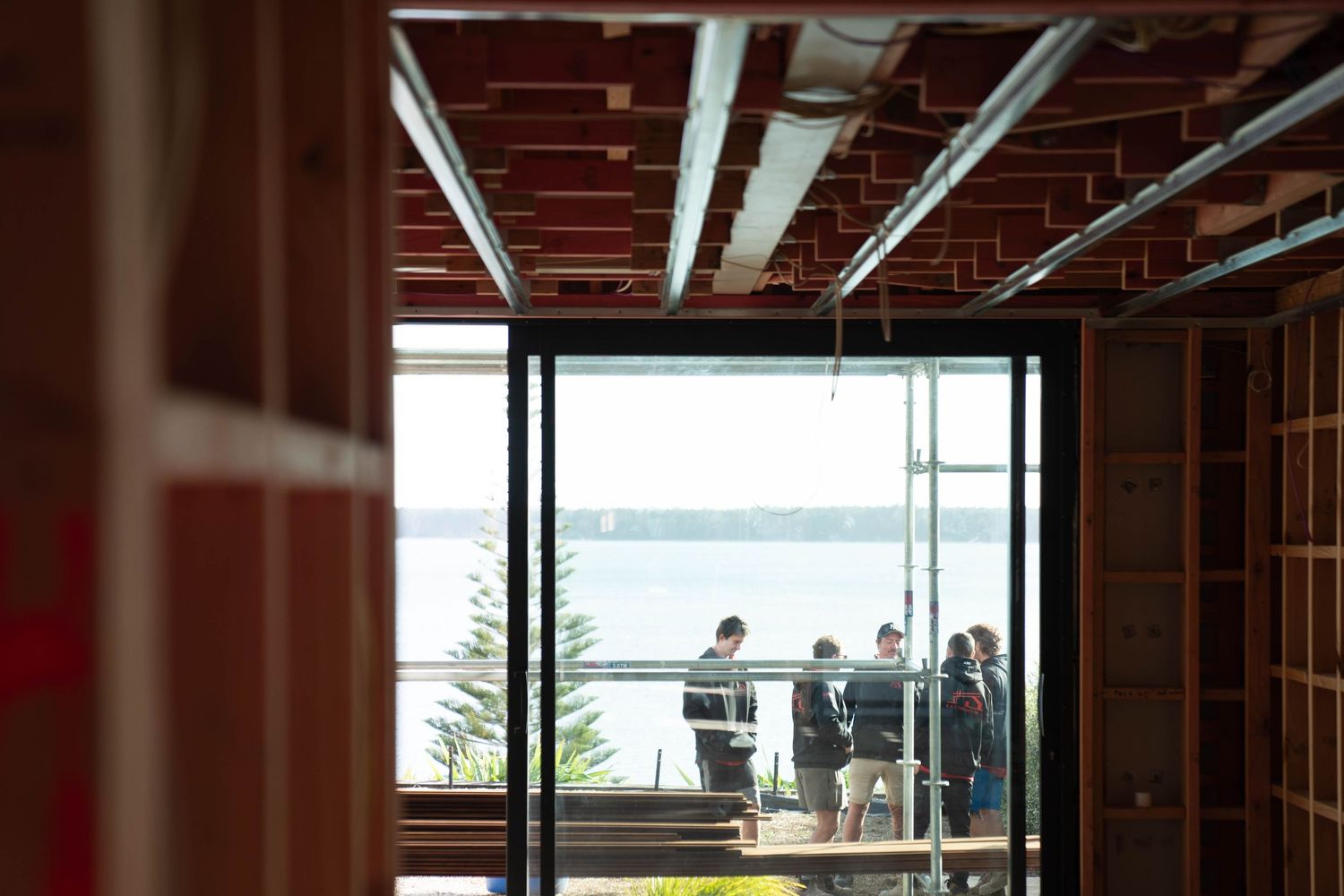 Modern kitchen renovation with exposed brick wall and hardwood flooring showcases sleek design and waterfront views.