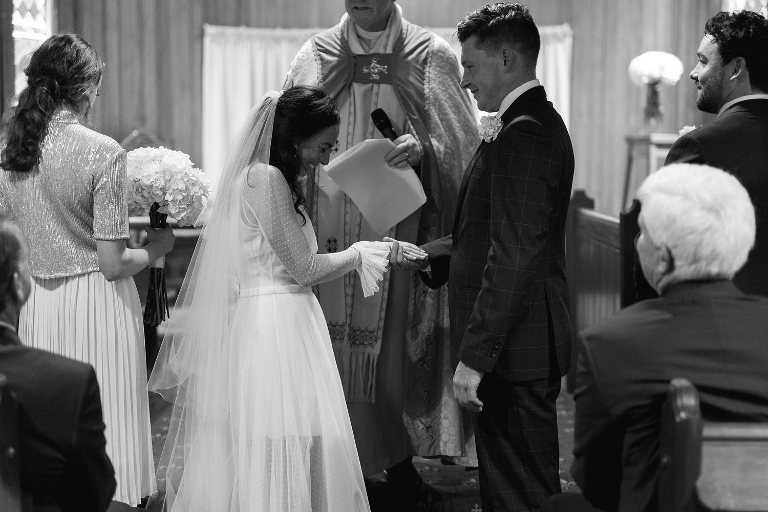 Couple sharing their first dance at a wedding reception with guests watching in an elegant ballroom.