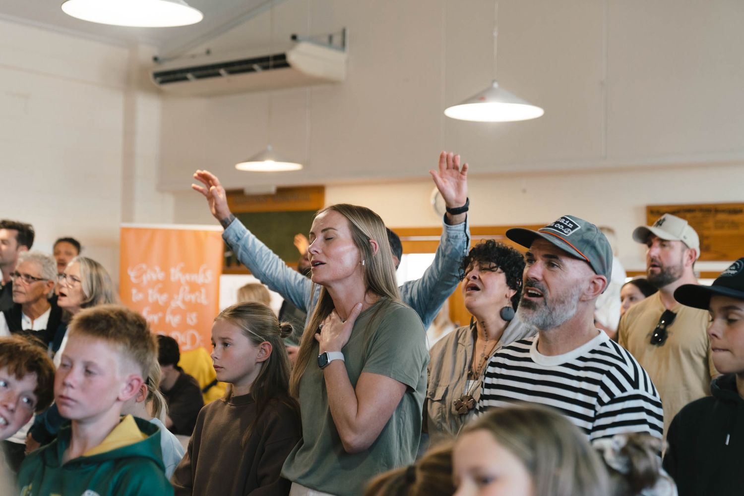 A congregation with raised hands during a worship service.