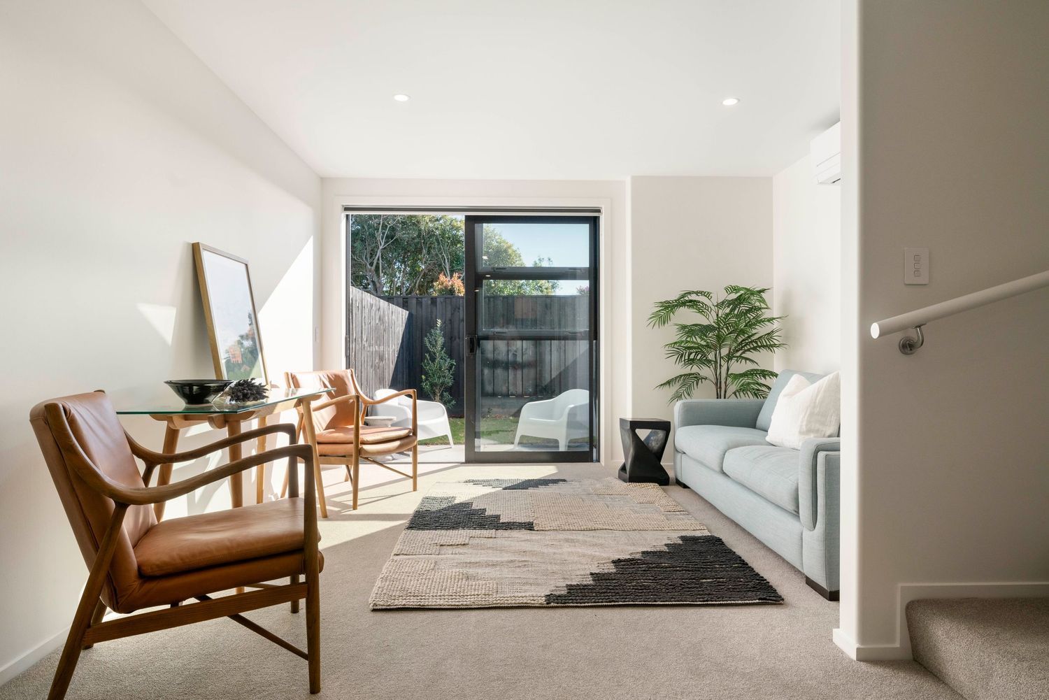 Modern living room with Danish furniture, sliding glass doors, and natural light.