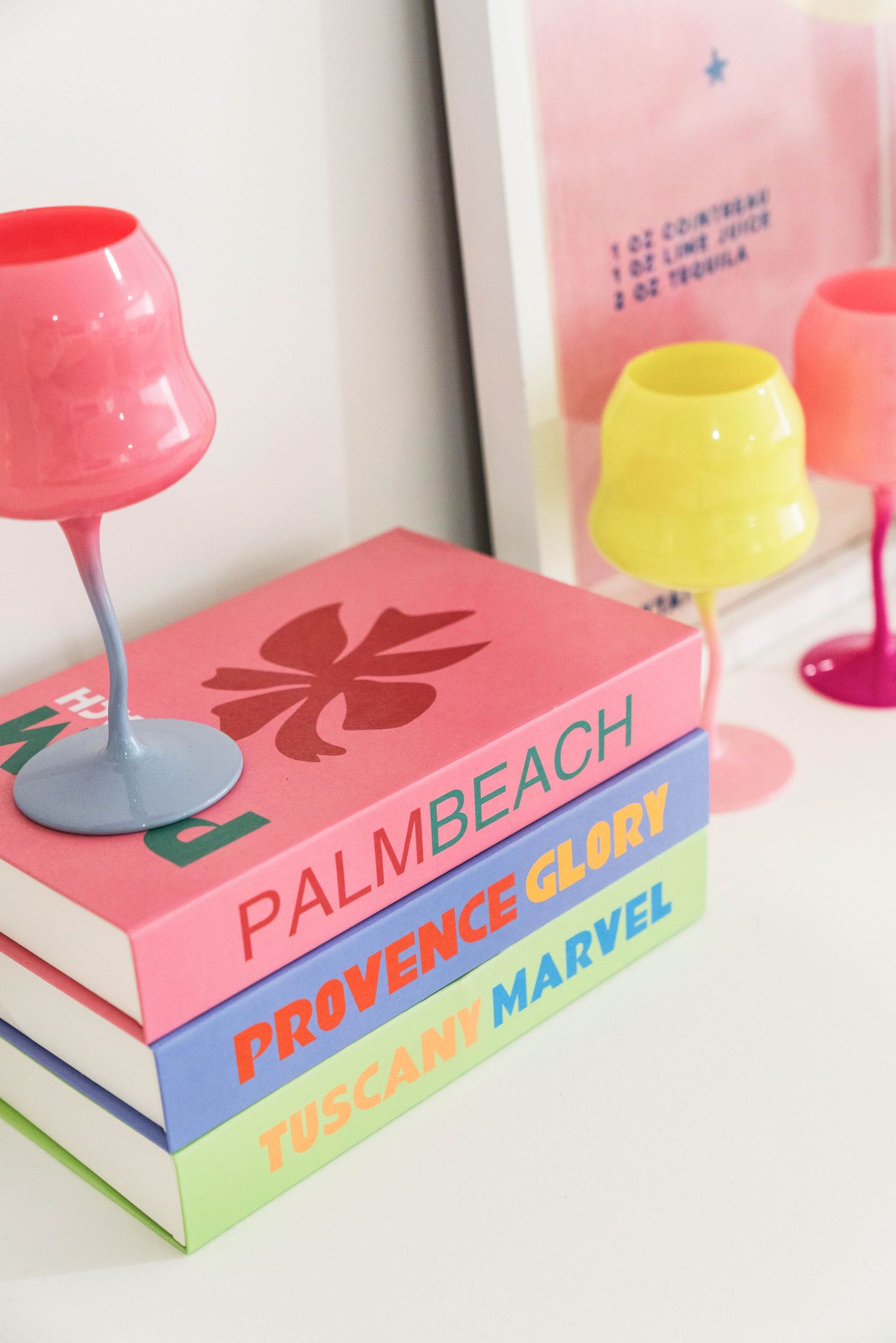 Colorful retro-style books arranged with pink and yellow decorative lamps creating a playful display.