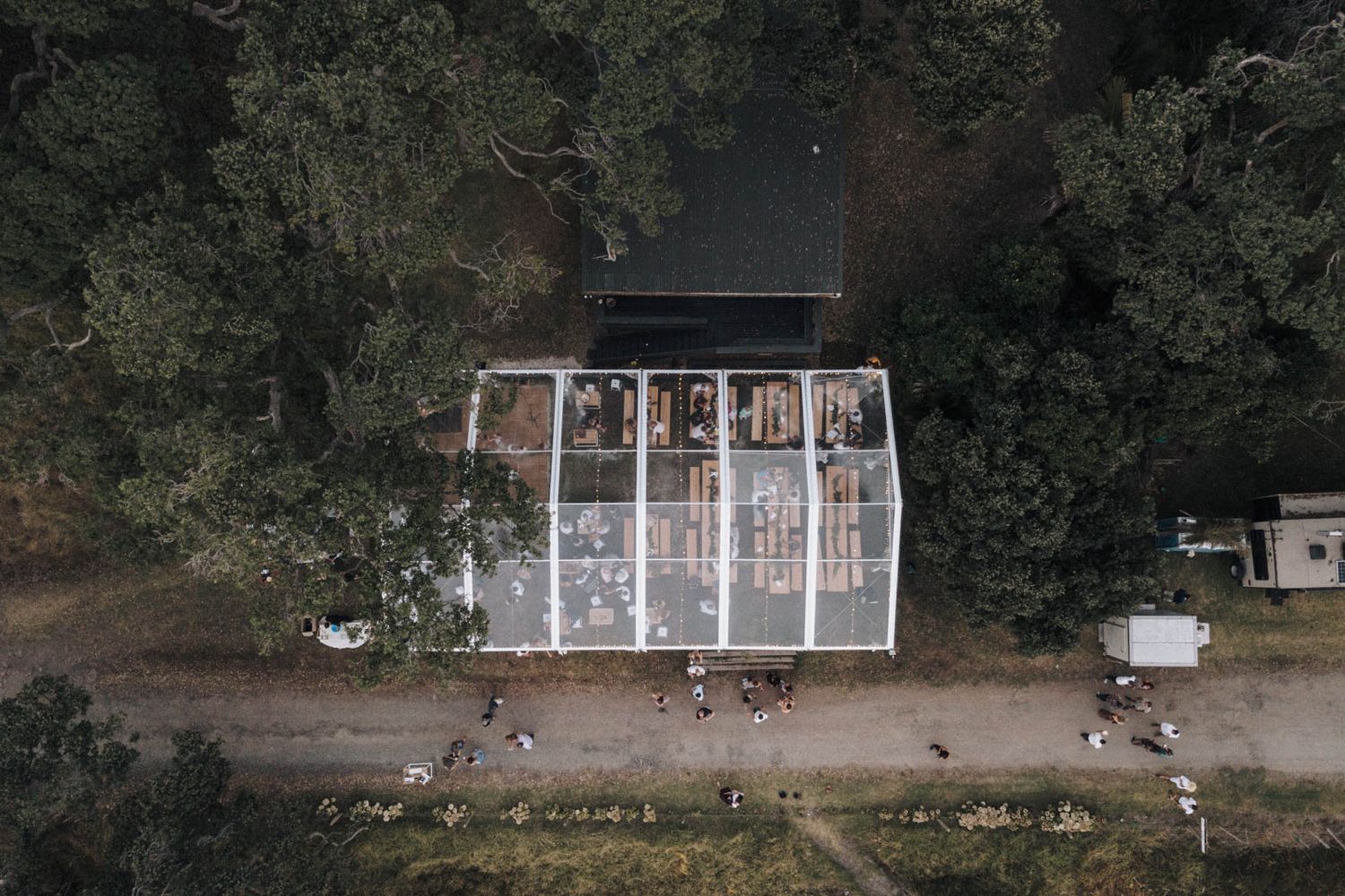 Seven dark and atmospheric outdoor photos show an abandoned structure with white beams and columns at twilight.