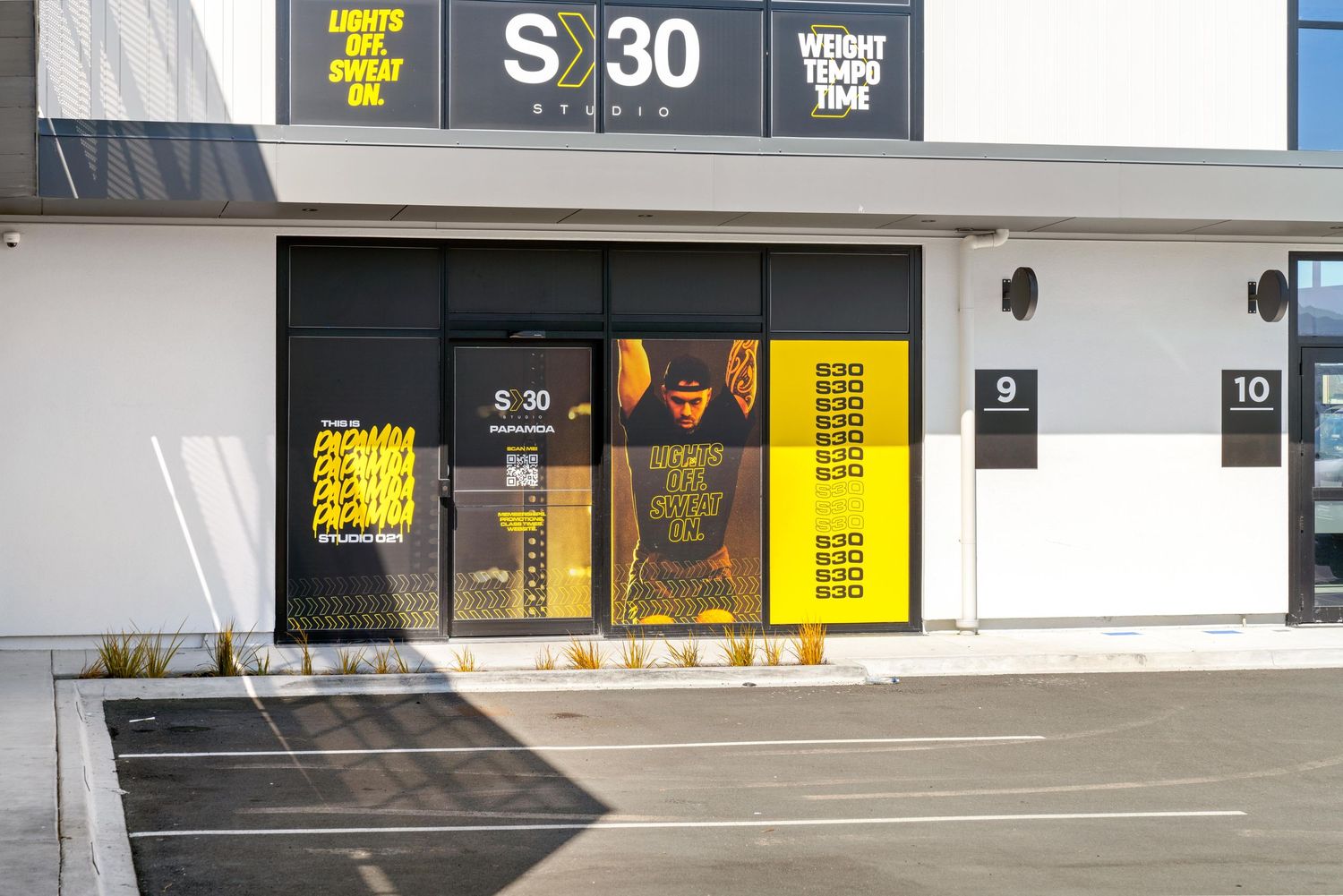 Yellow and black signage on modern commercial building facade with clean white exterior.