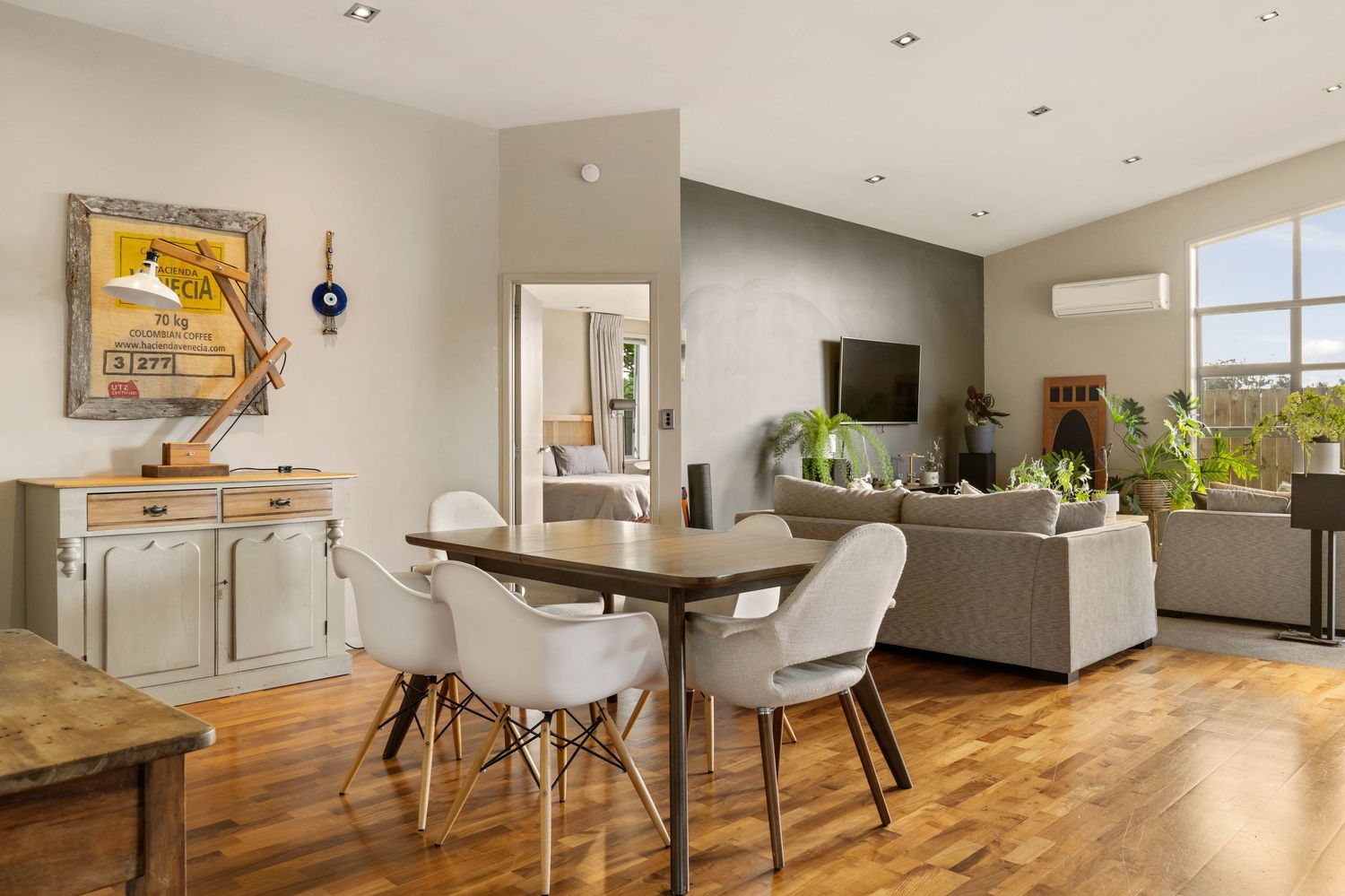 Open concept living space with modern dining area, hardwood floors and contemporary furnishings.