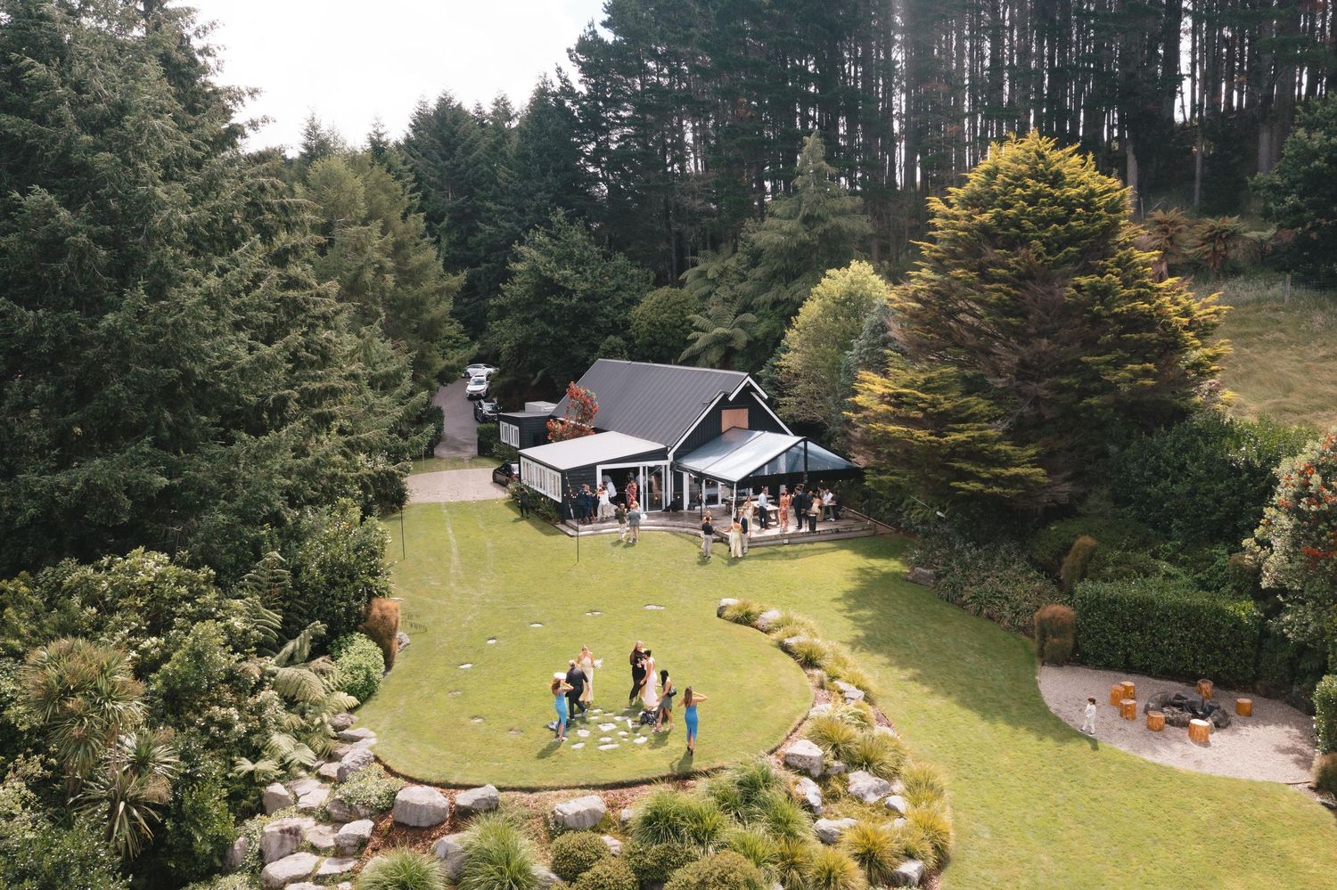 Bird's eye view of a small wedding venue nestled in a forested hillside.