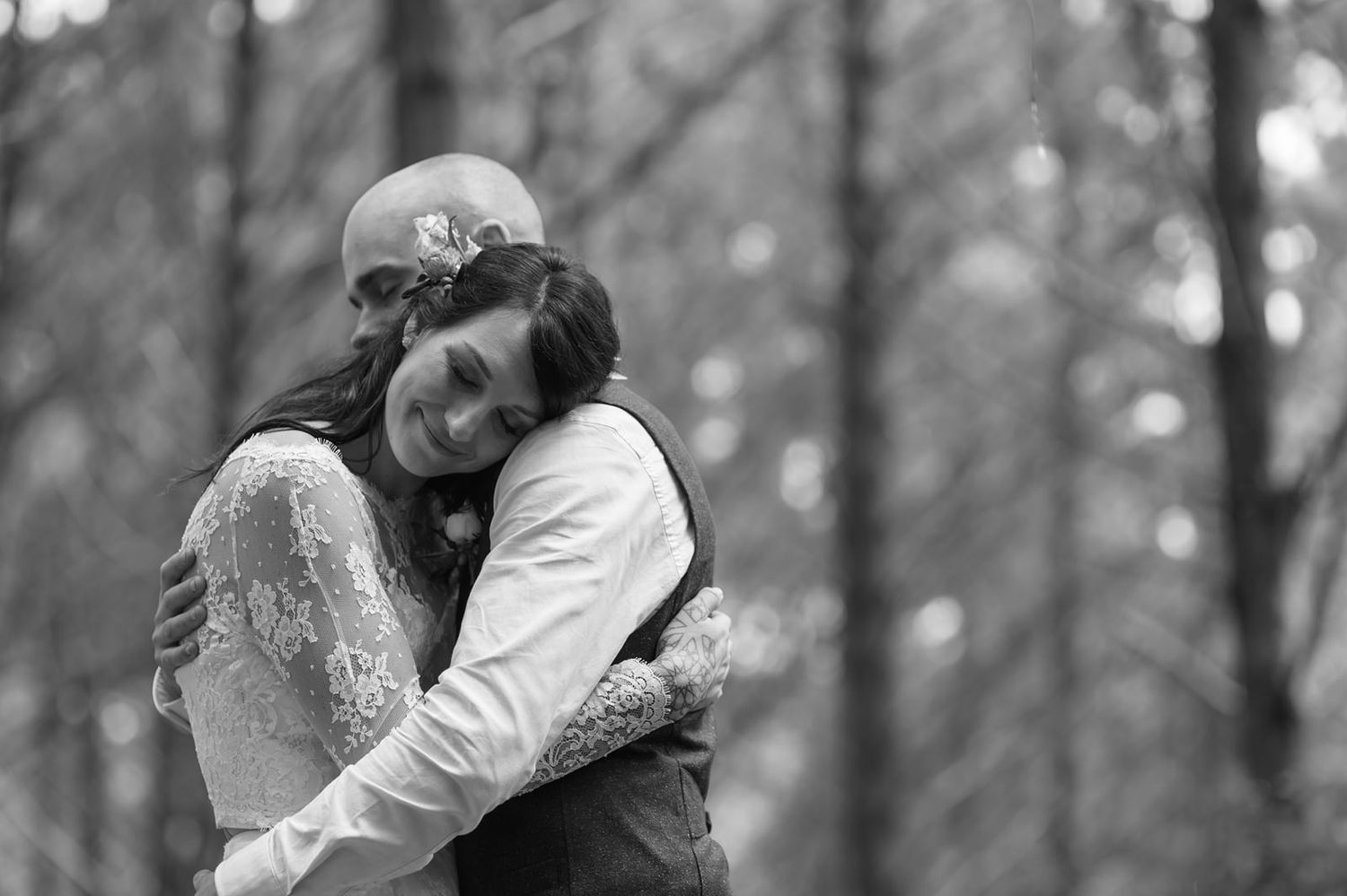 Black and white intimate moments captured between couple during forest wedding photoshoot.