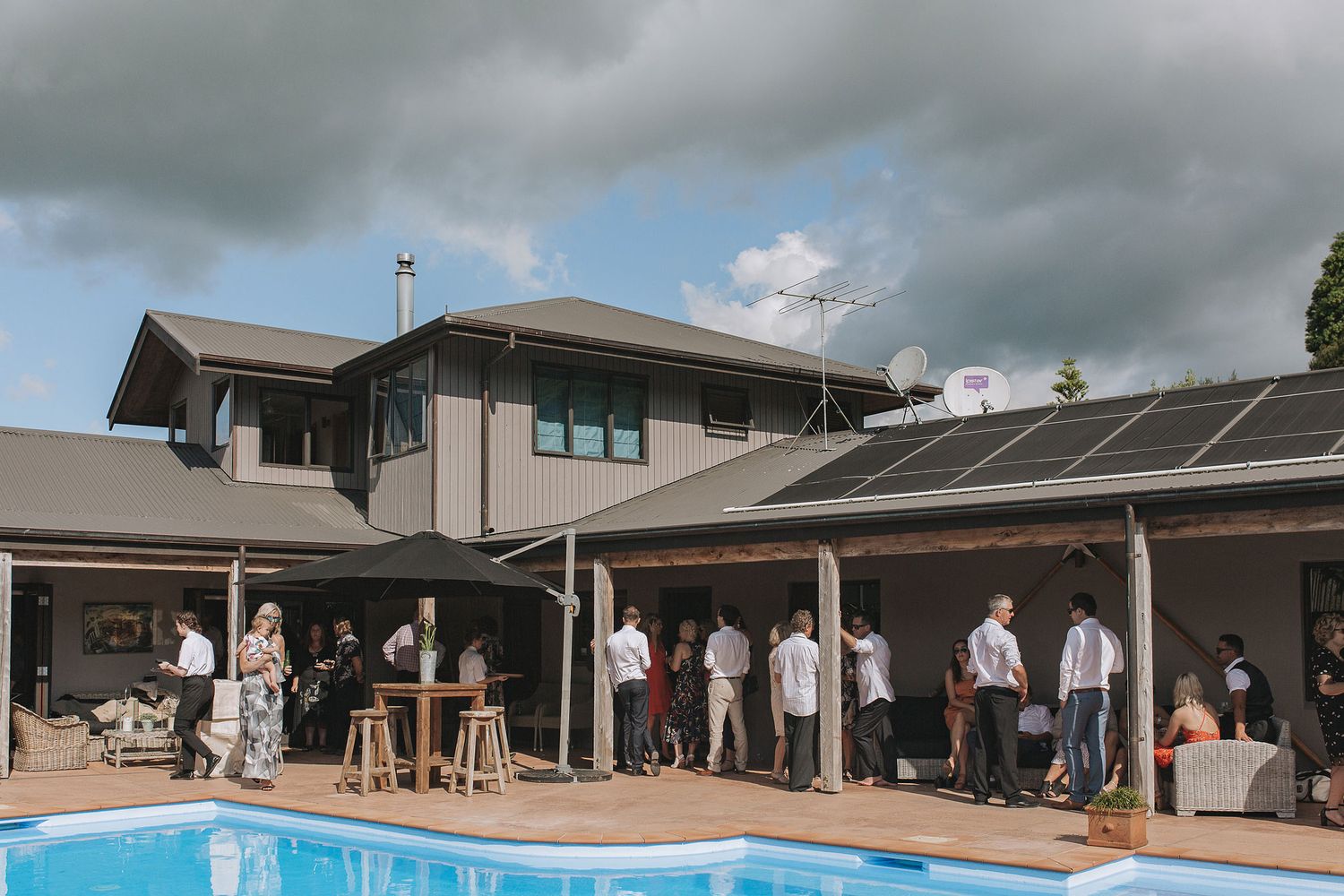 Students in white uniforms gather for an event under cloudy skies at an educational facility.