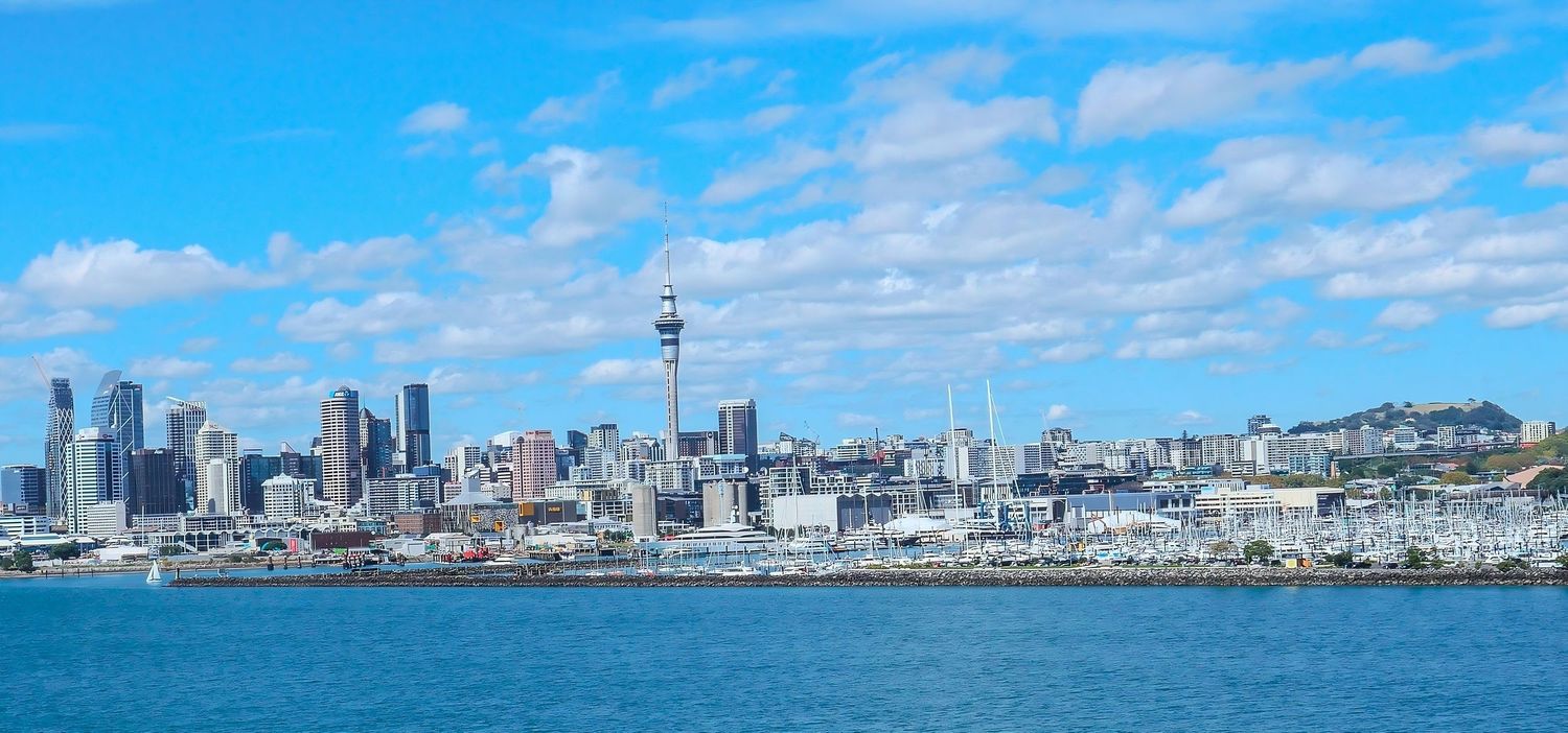 A photo of Auckland's skyline, which features the sky tower, on a sunny day.