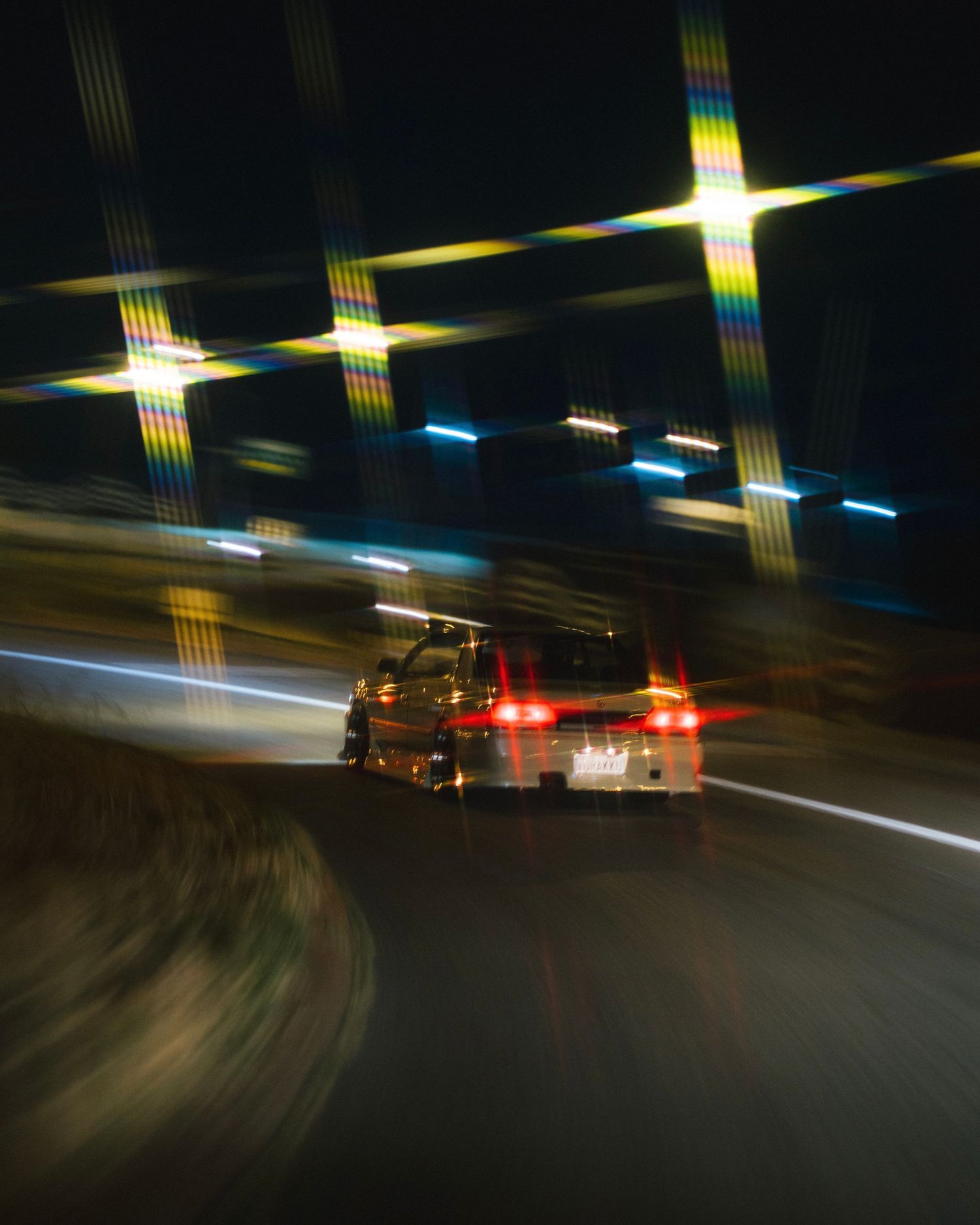 Night street racing scene with motion-blurred cars and streaking lights.