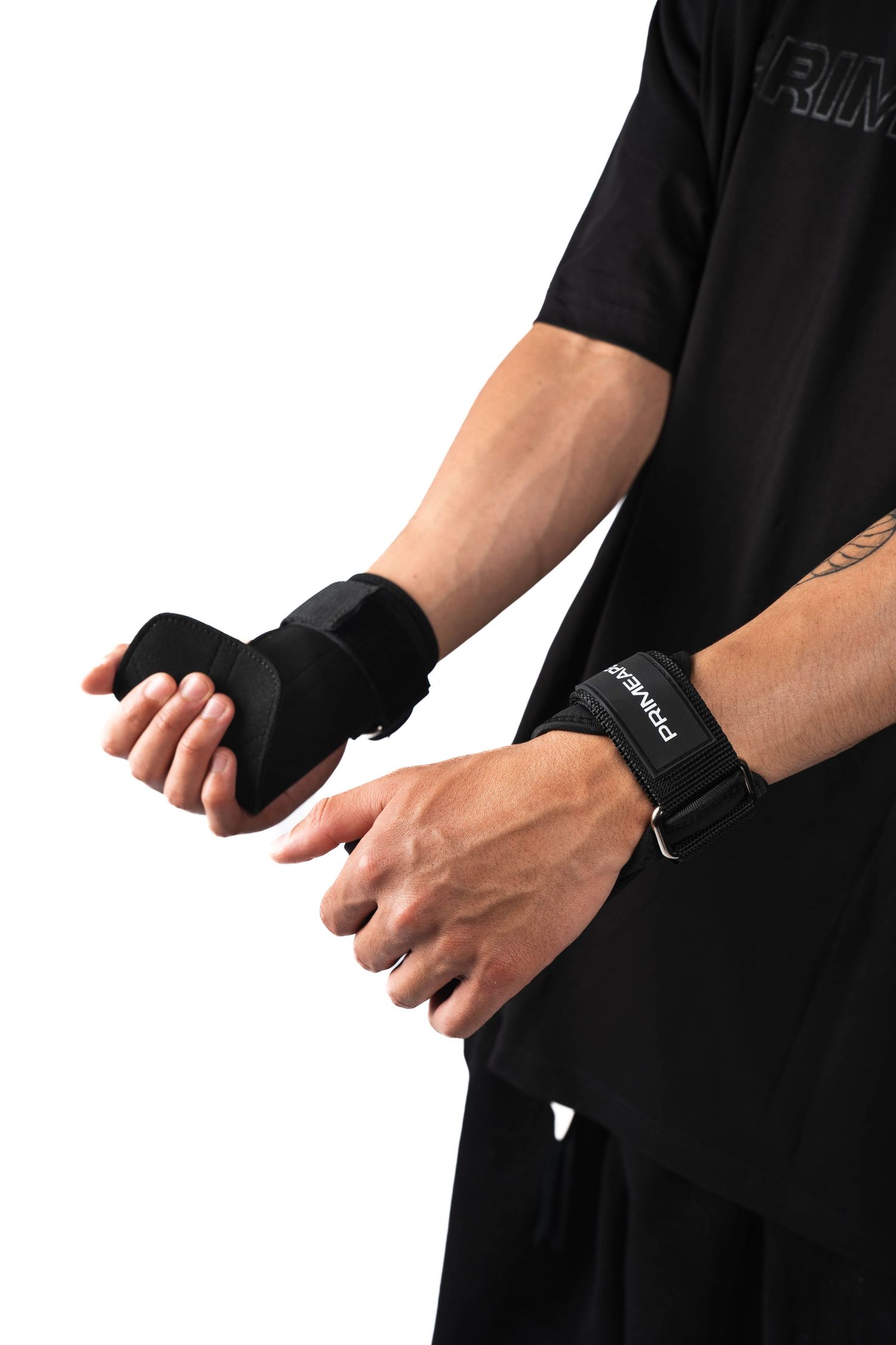 Person wearing black athletic wear adjusts protective wrist and hand support wraps for fitness training or sports.
