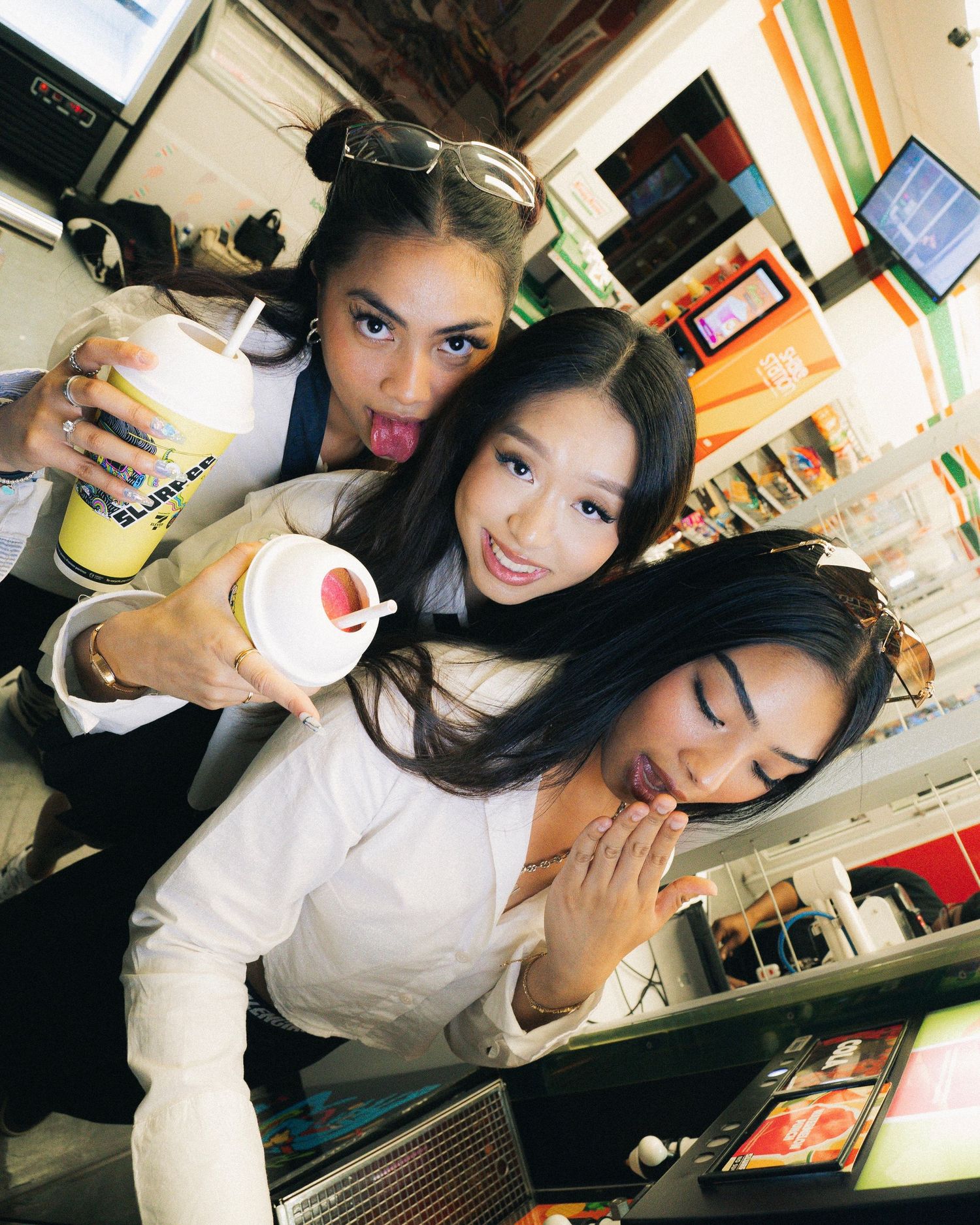 Friends posing together with drinks in casual setting with warm lighting.