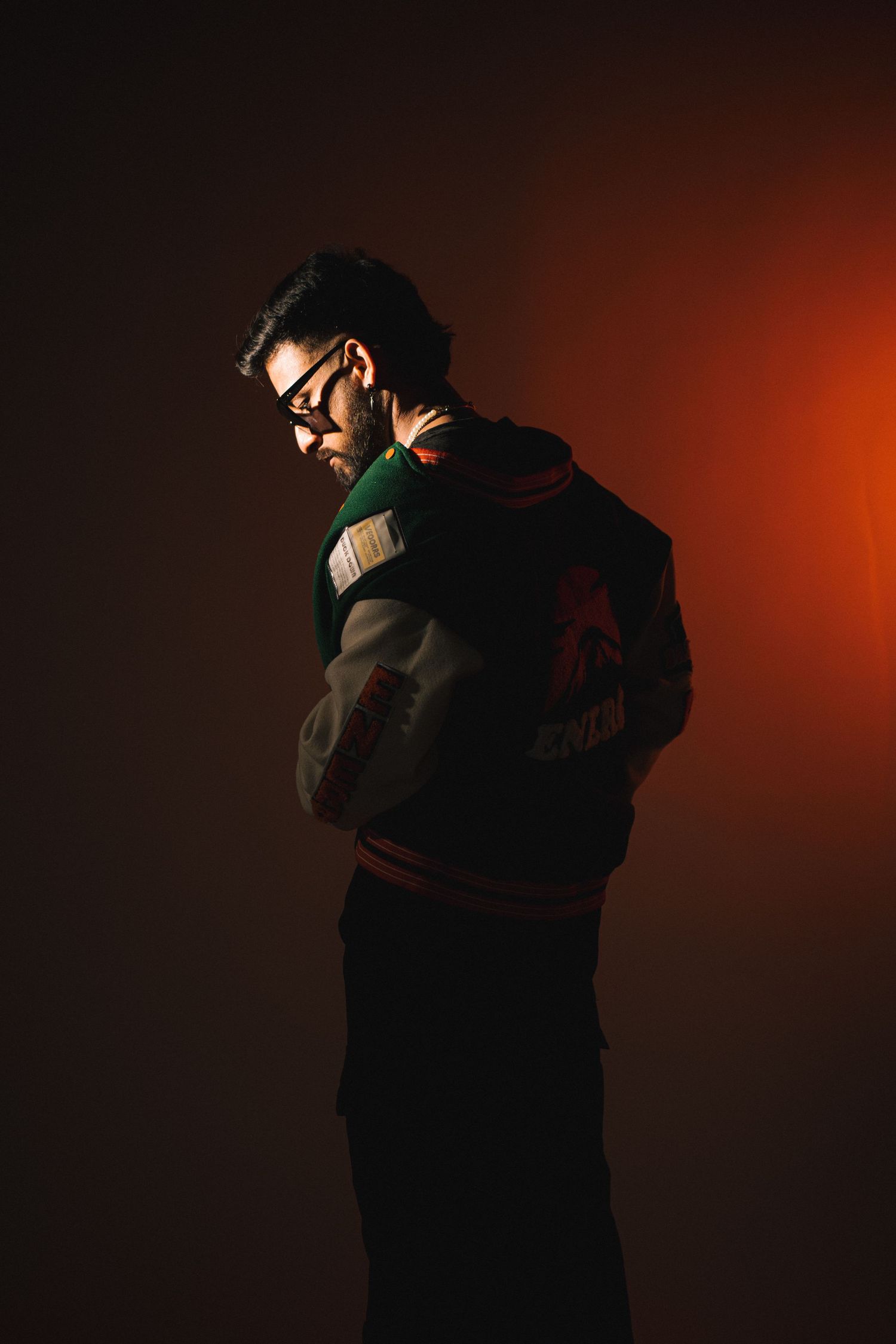 Two people cast silhouettes in a dramatic dance pose against a dark reddish-orange background.