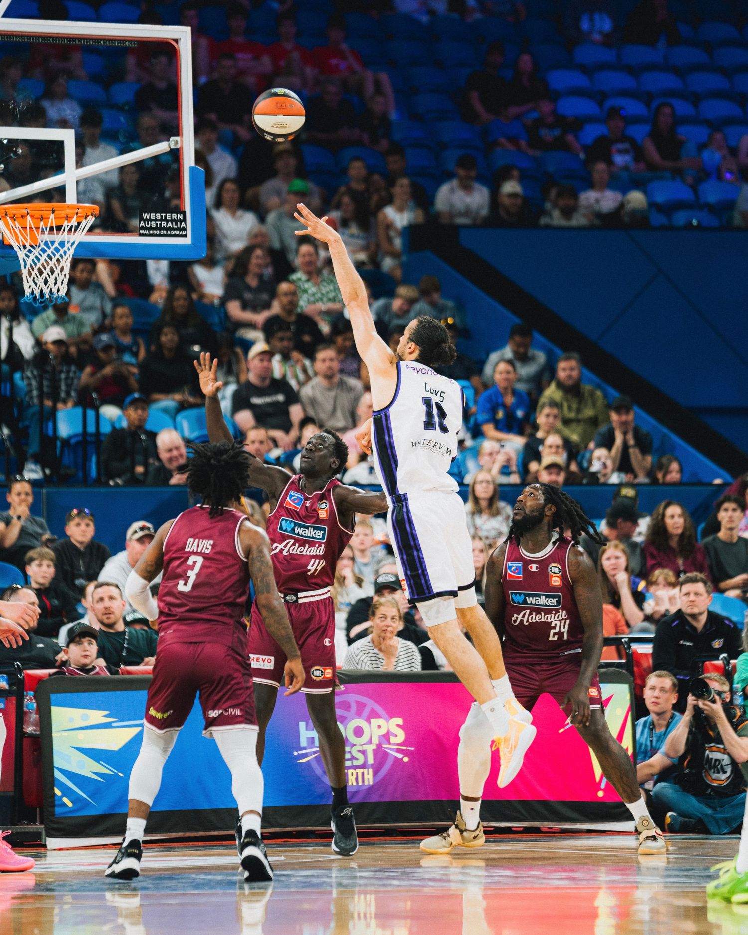 Professional basketball players competing for a rebound during an intense game.