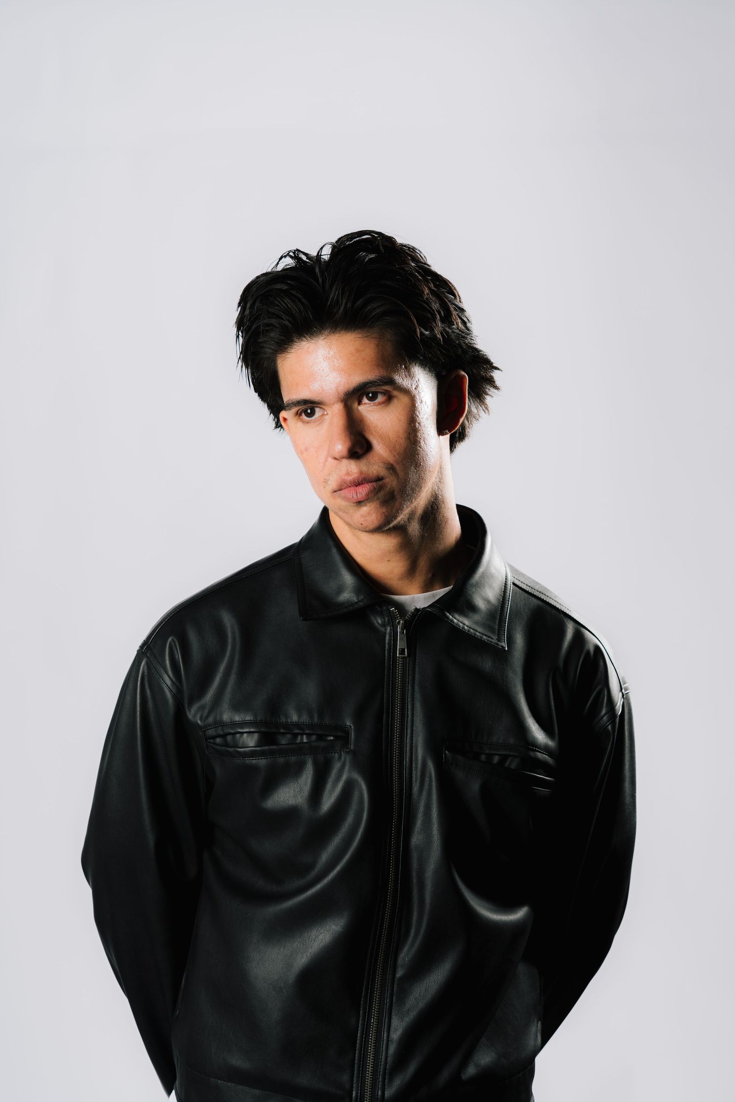 Four black and white studio shots of someone wearing a black leather jacket against a neutral background.