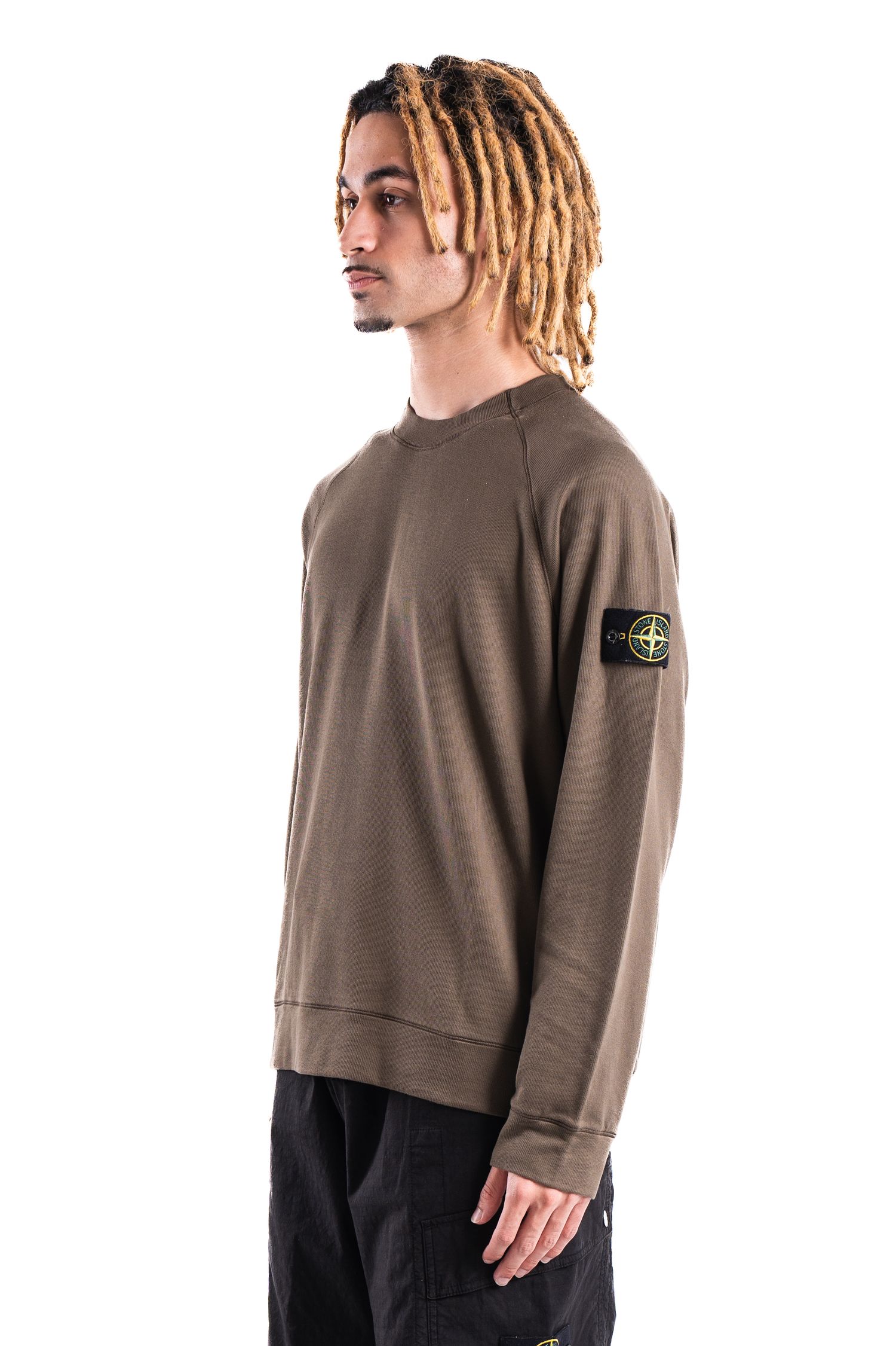 Stone Island military green sweatshirt with signature patch badge on sleeve shown on model.