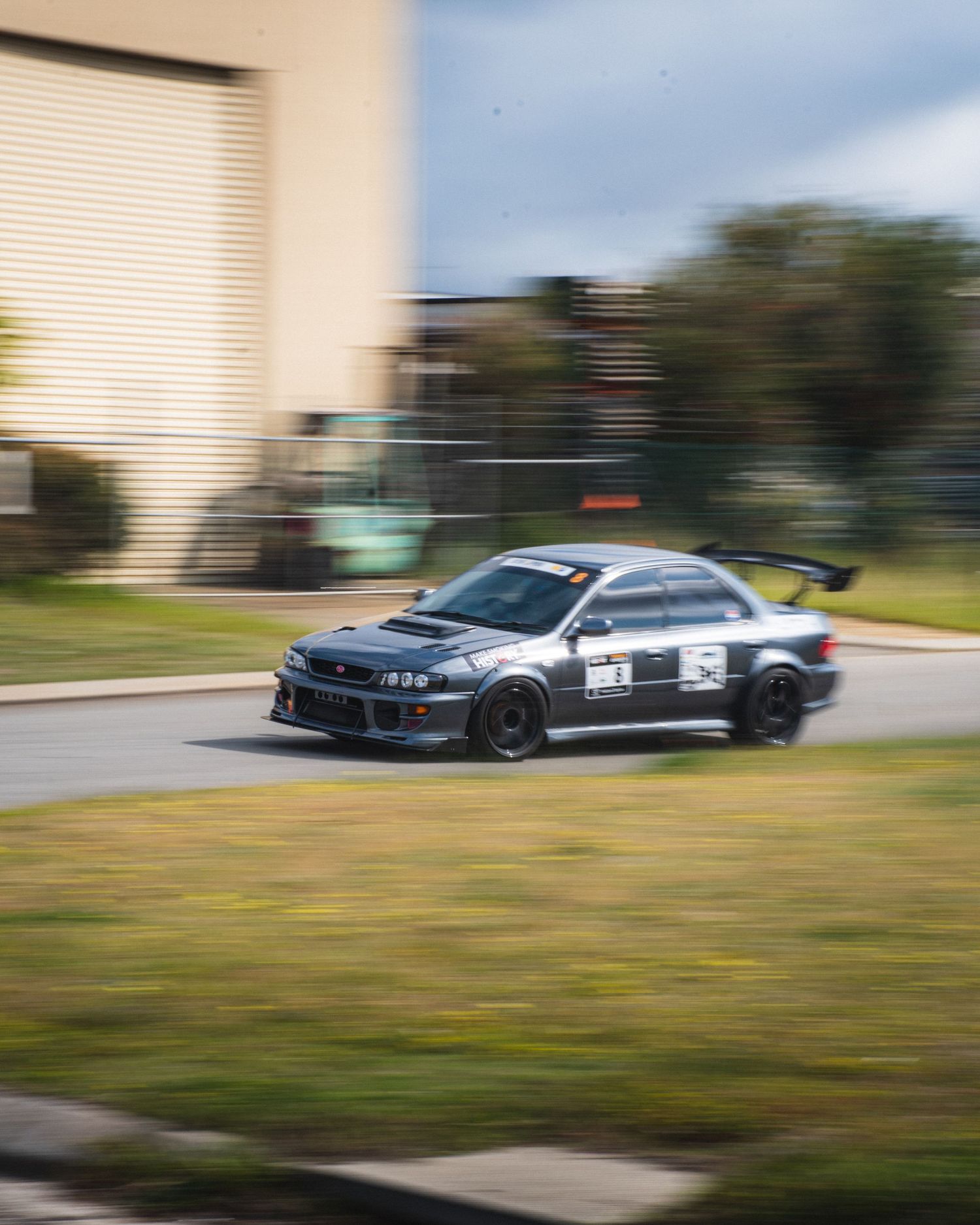 Yellow vintage sedan racing at high speed on a street circuit.