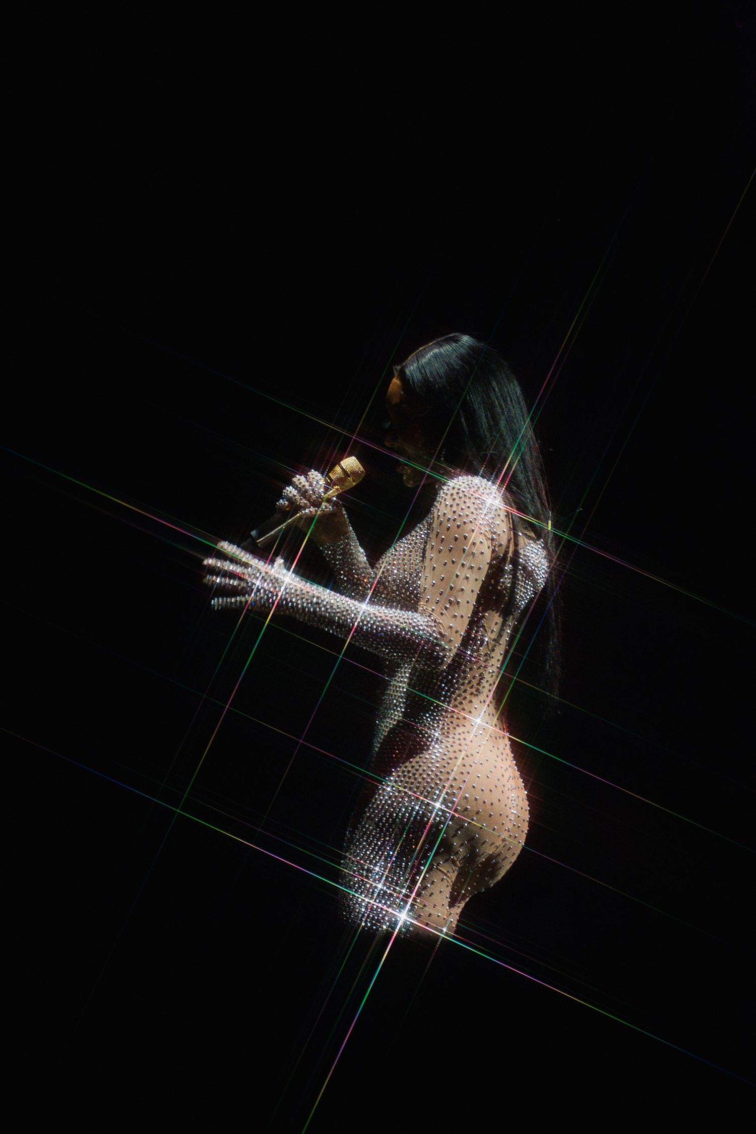 Artistic silhouette of person with glitter effect dancing against dark background with geometric lines.