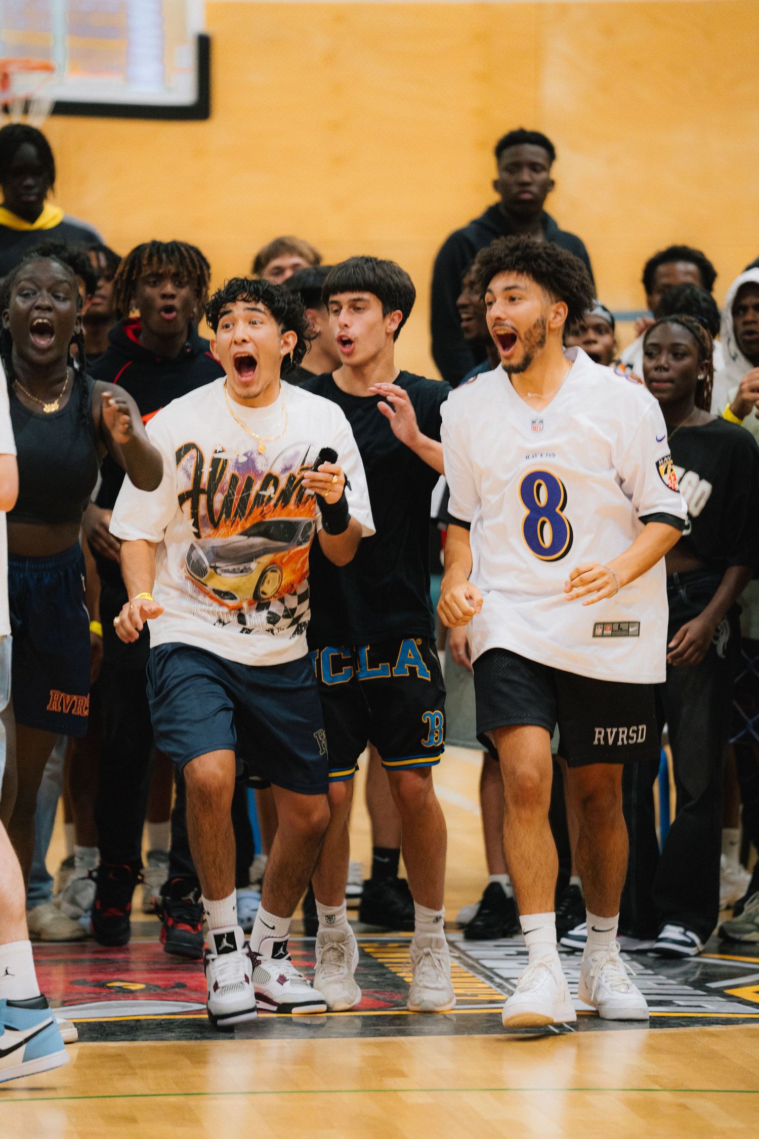 Excited group of young people cheering and reacting during a basketball game.