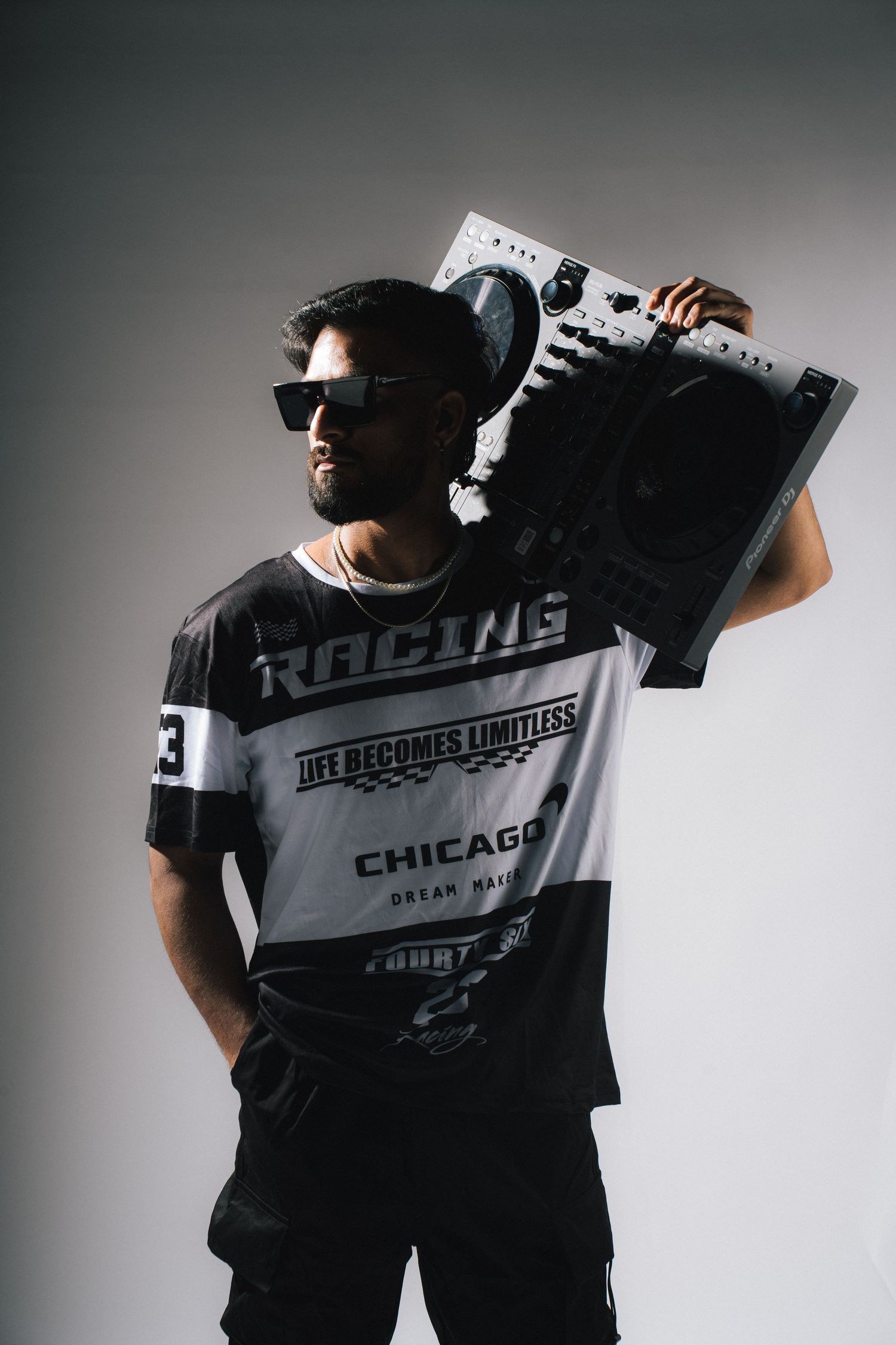 Urban style portrait of person holding boombox wearing sunglasses and graphic t-shirt.
