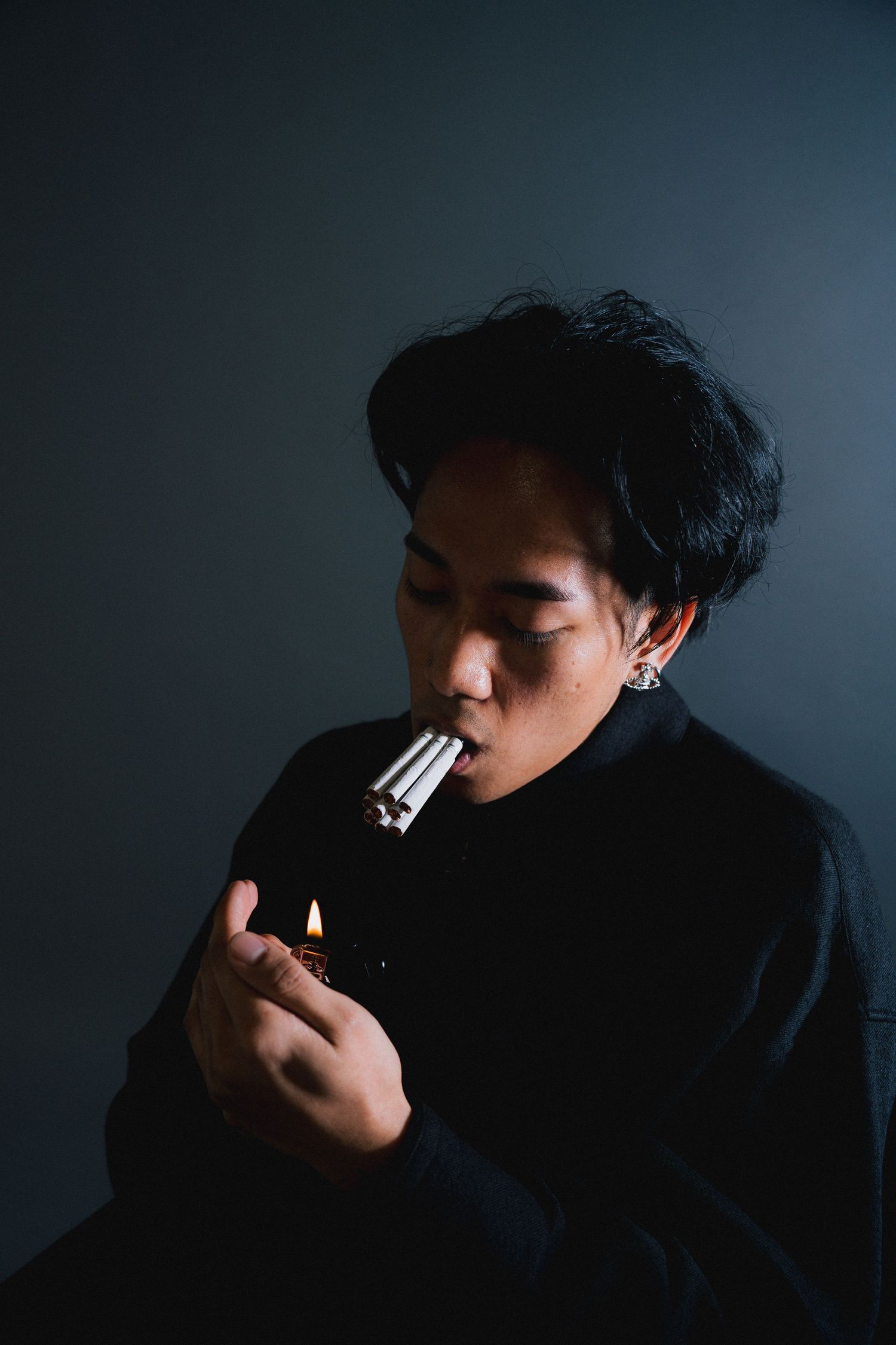 A moody series of silhouettes showing a person smoking against a dark background.