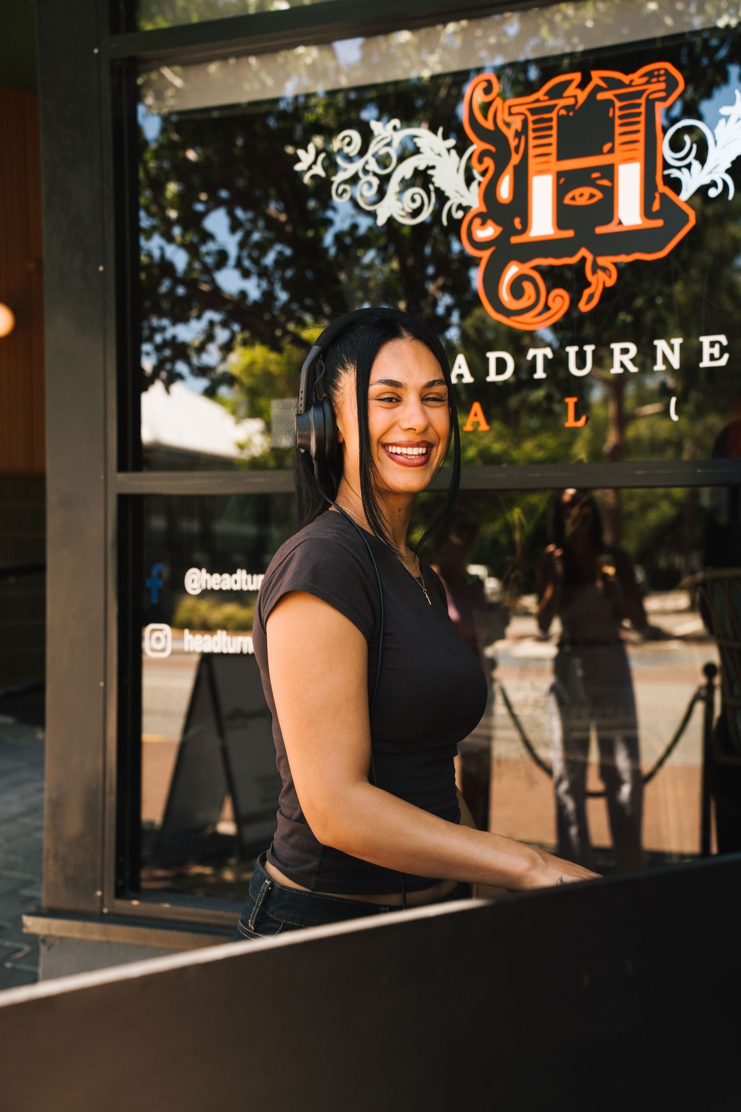 Restaurant employee smiling while working at Adturne establishment during golden hour lighting.