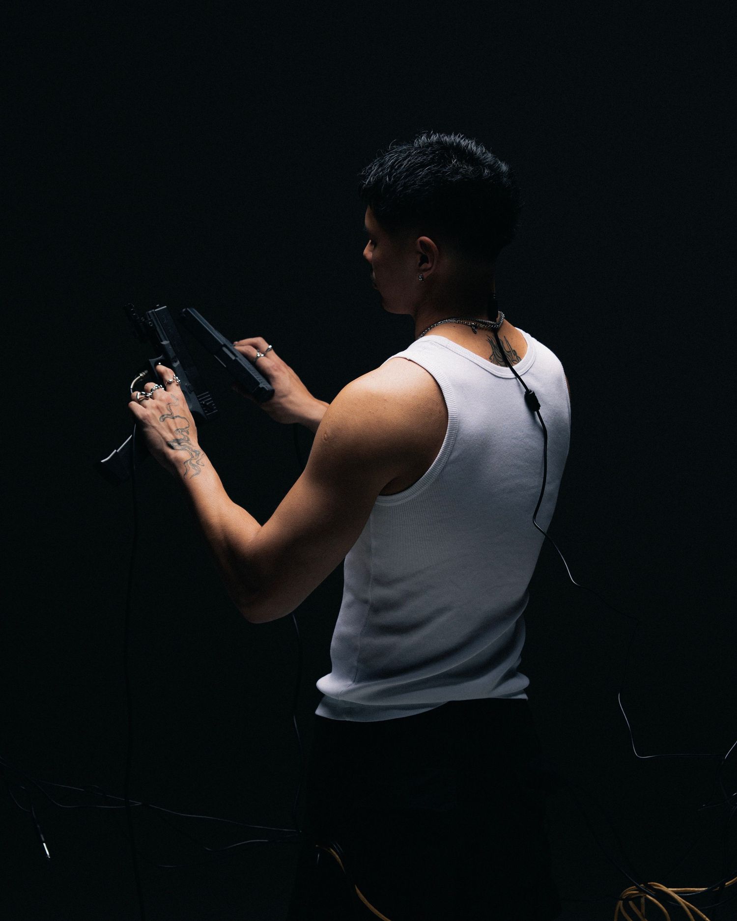 A person in silhouette against dark background aiming and firing a pistol target practice sequence.