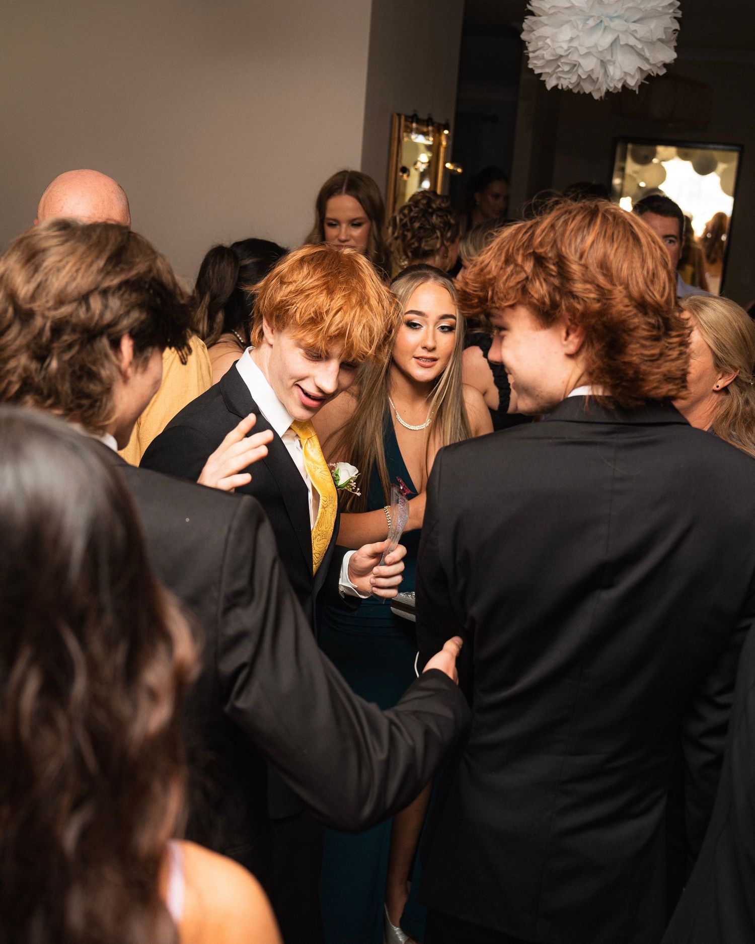 Group of formally dressed people socializing at an indoor party.