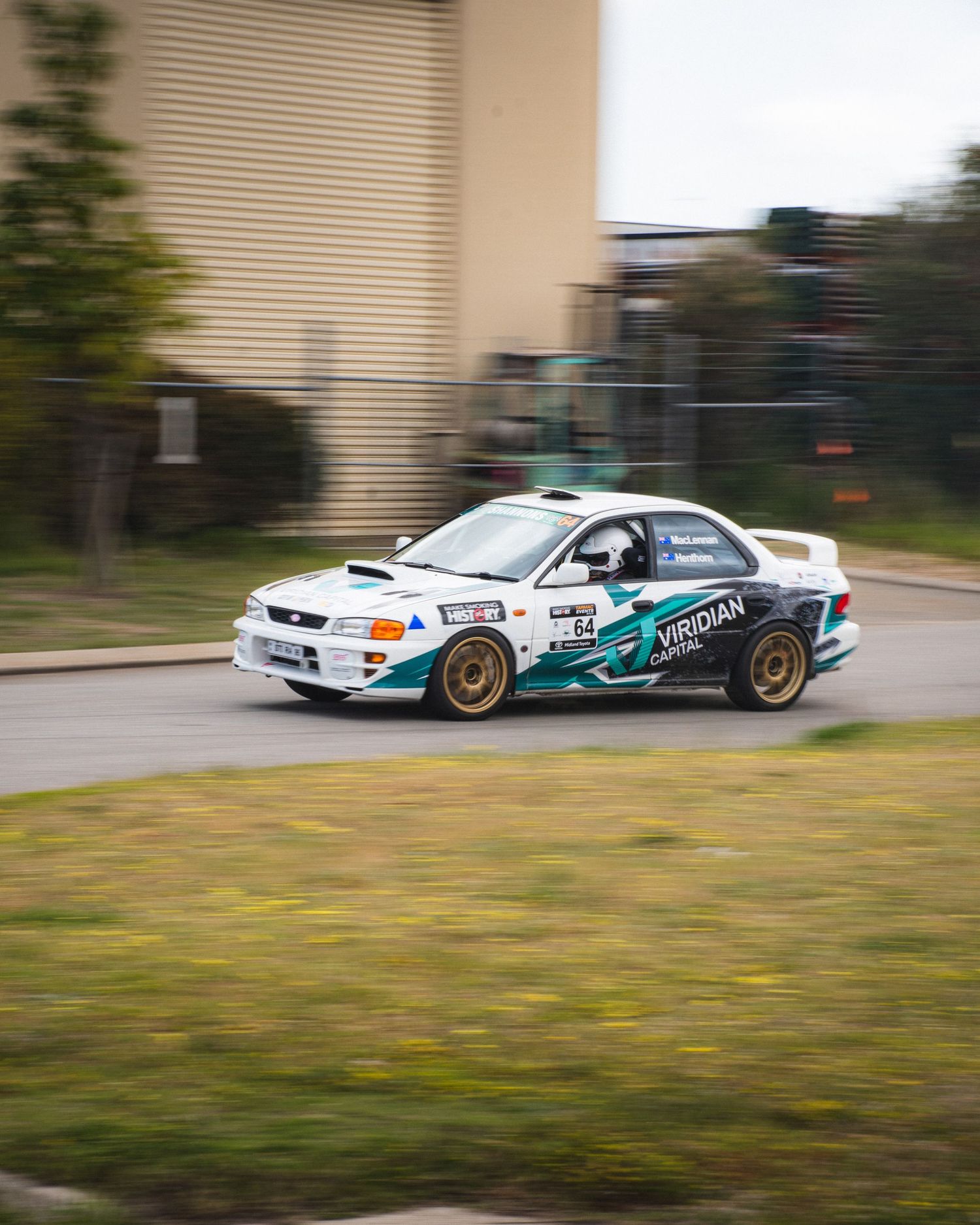 Modified Subaru drifting in motion on a racetrack with custom livery and performance upgrades.