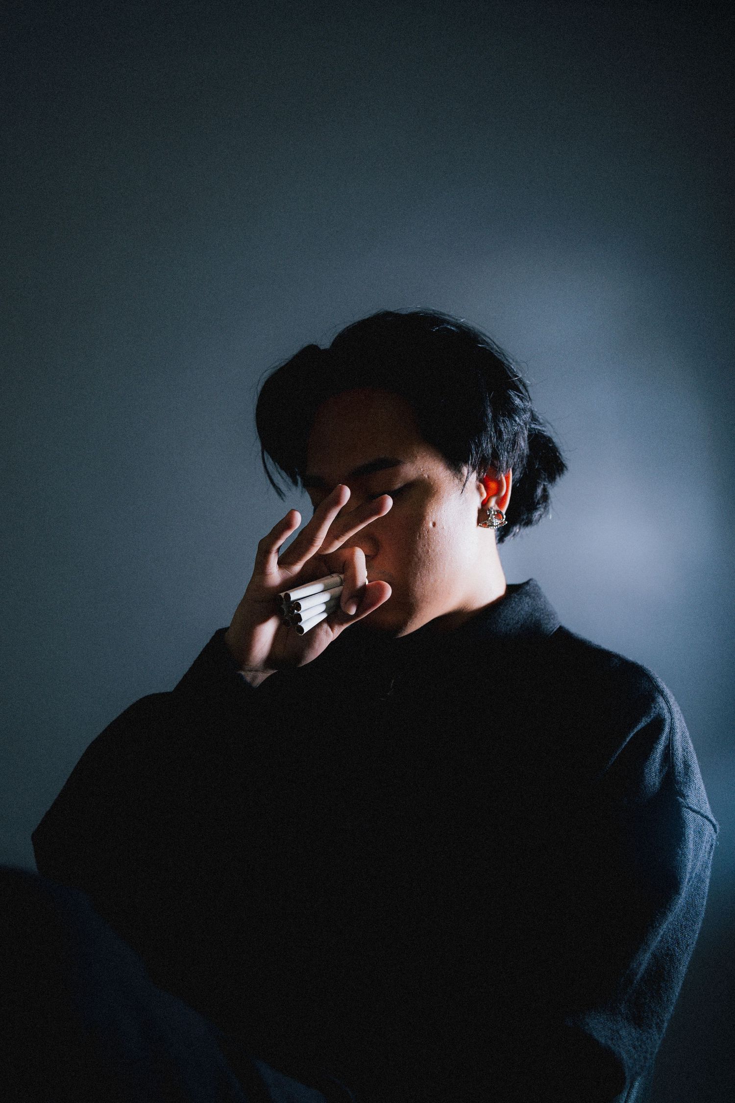 Moody profile silhouettes against dark background create dramatic sequence showing person covering their face.