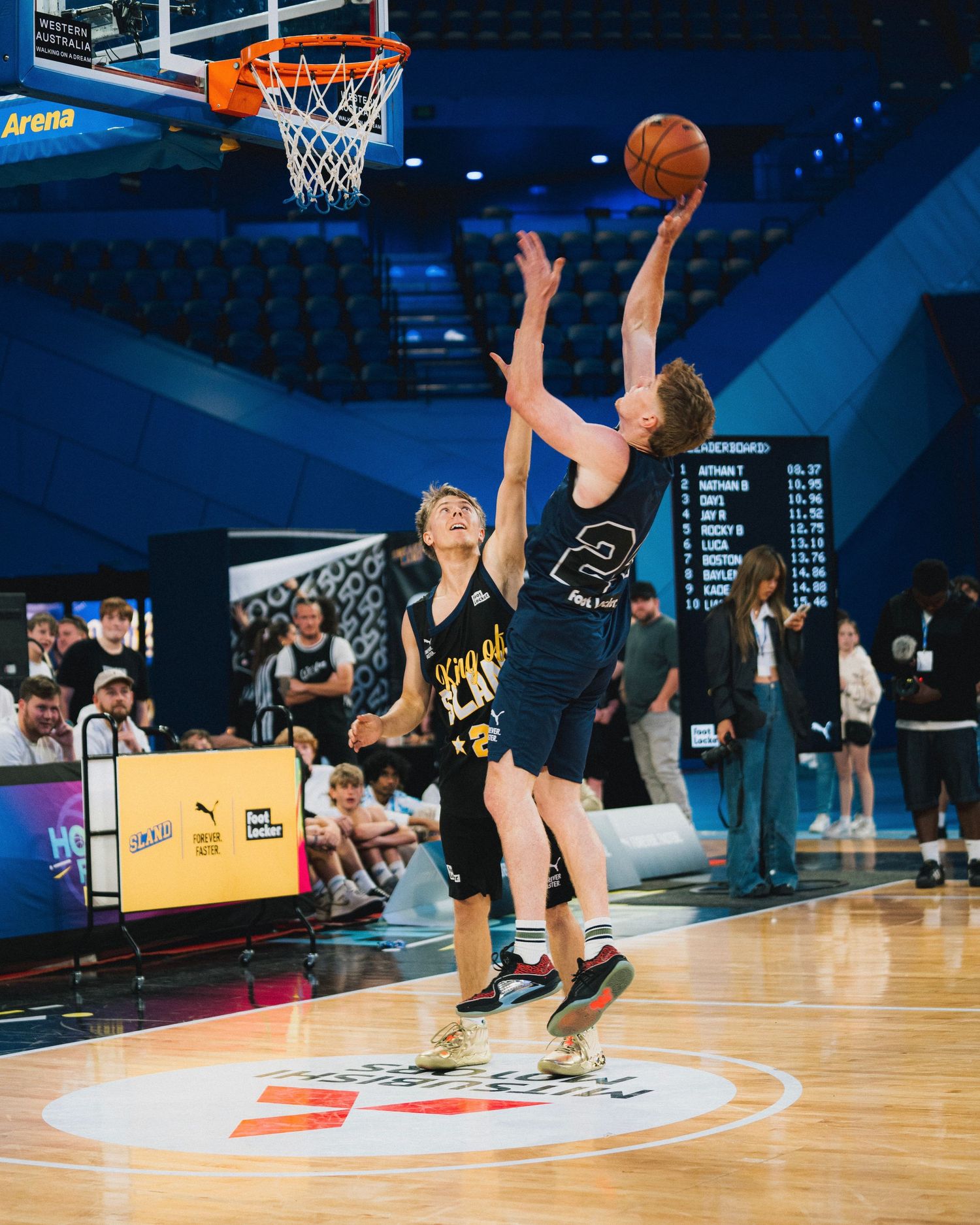 Basketball players compete for a shot during an intense game moment.