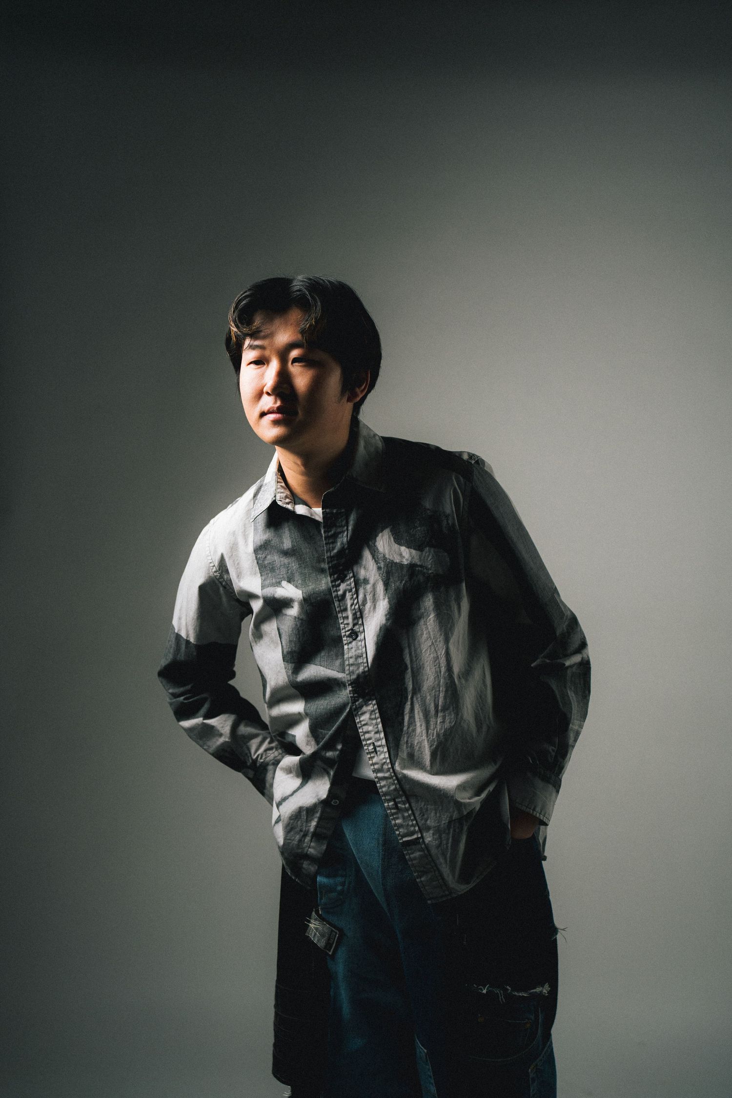 Portrait series showing dynamic poses of a person in a denim jacket against a minimalist gray backdrop.