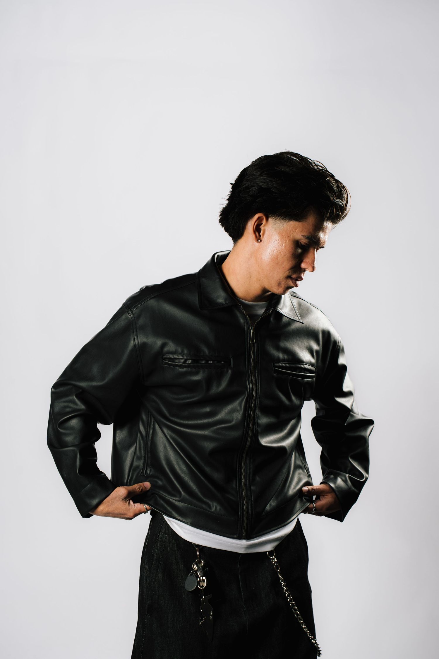 Black leather jacket worn in four different poses against white background with dramatic shadows.