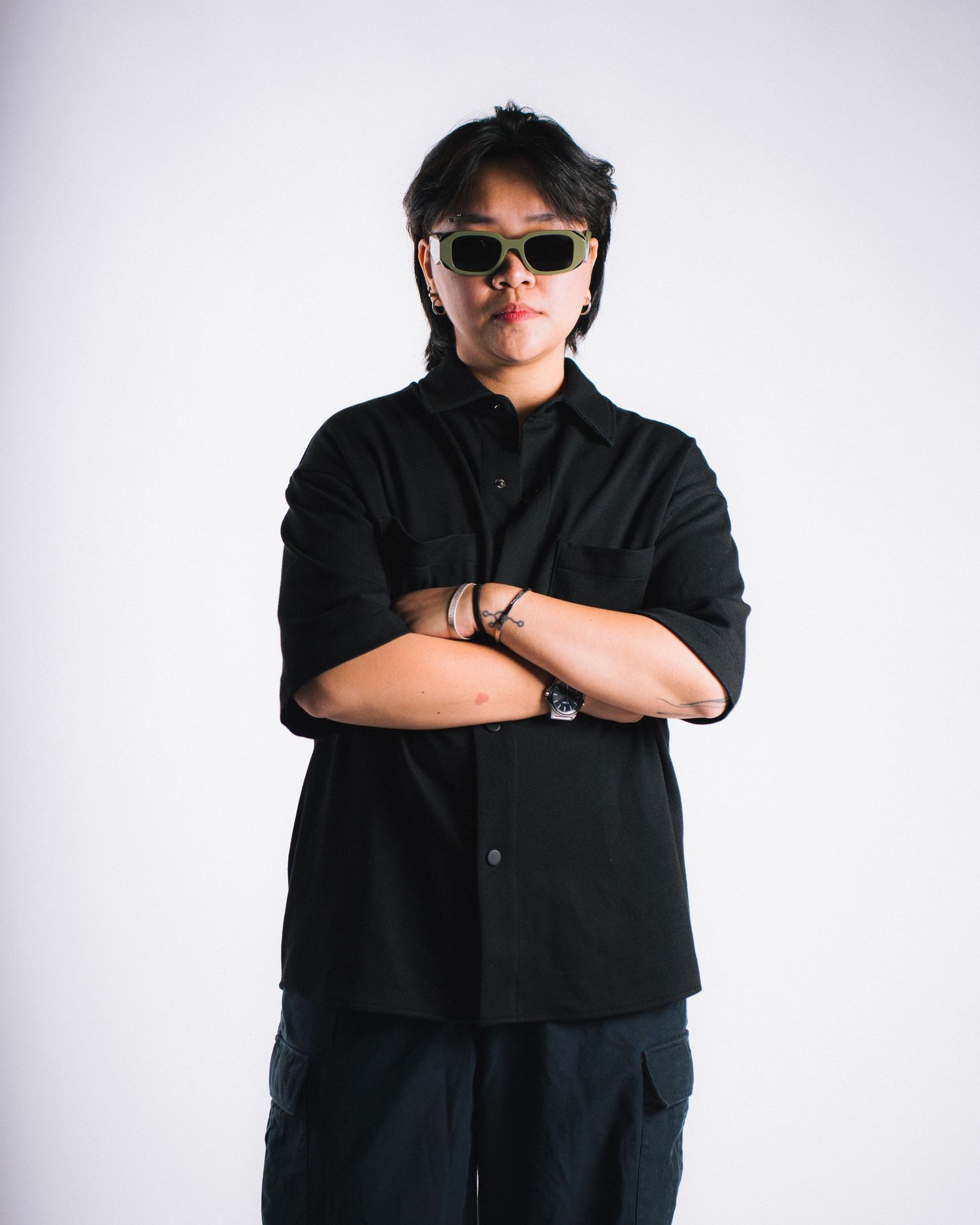 A five-part sequence of a figure wearing black clothing and sunglasses striking different poses against a white background.