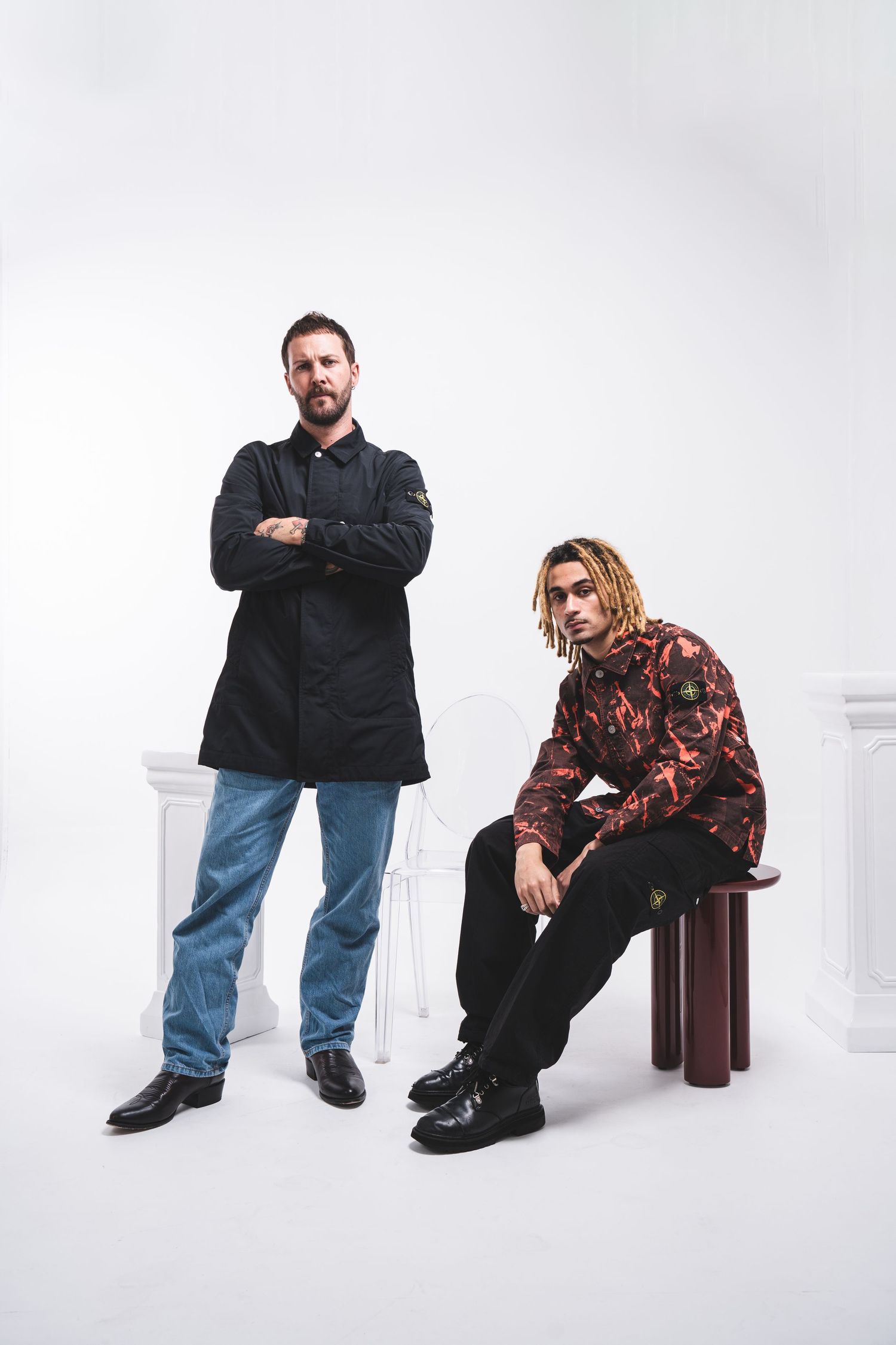 Fashion portrait of two people in contrasting casual and formal wear against white backdrop.
