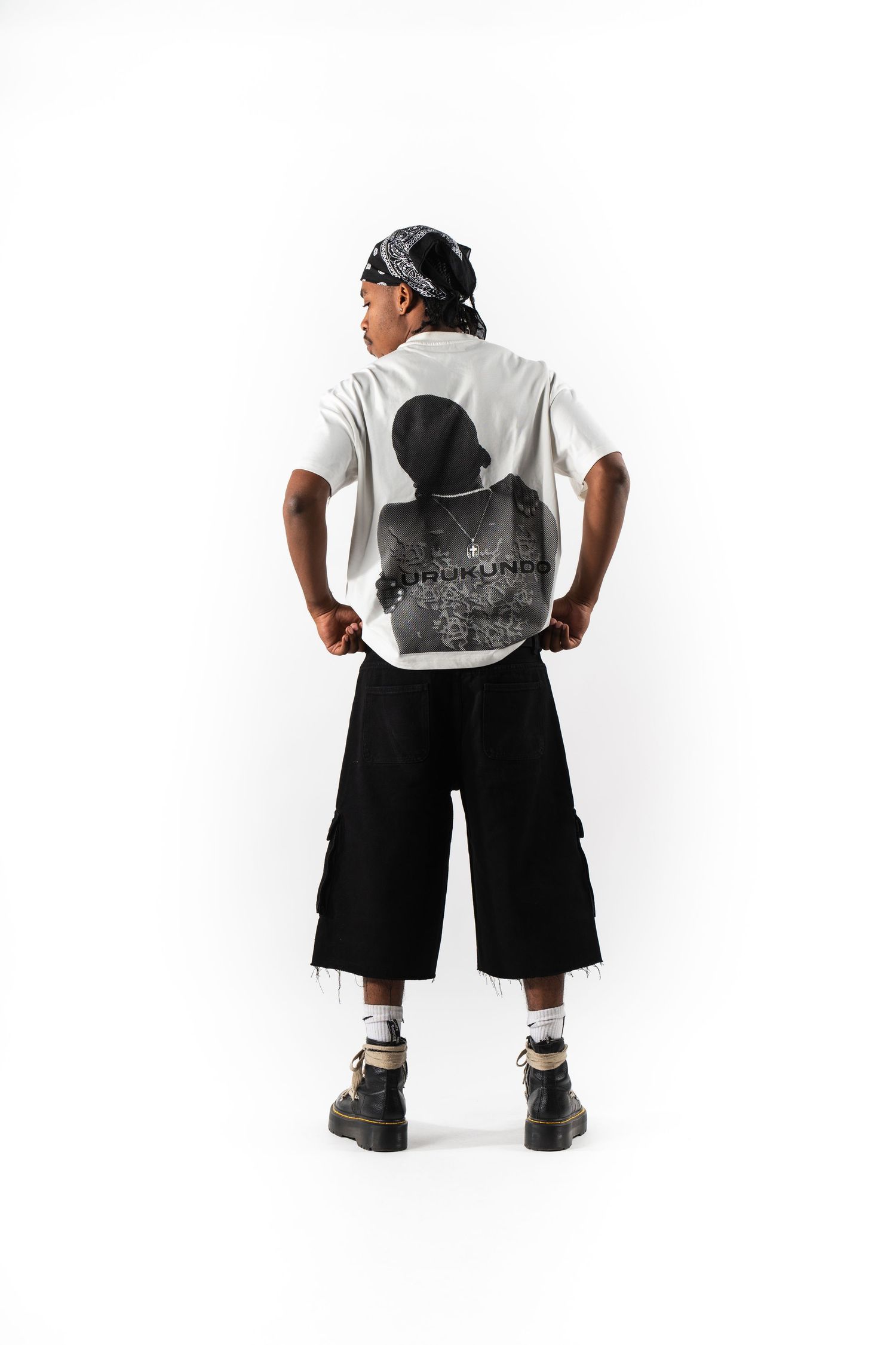 Back view of person wearing white graphic t-shirt and wide-leg black shorts.
