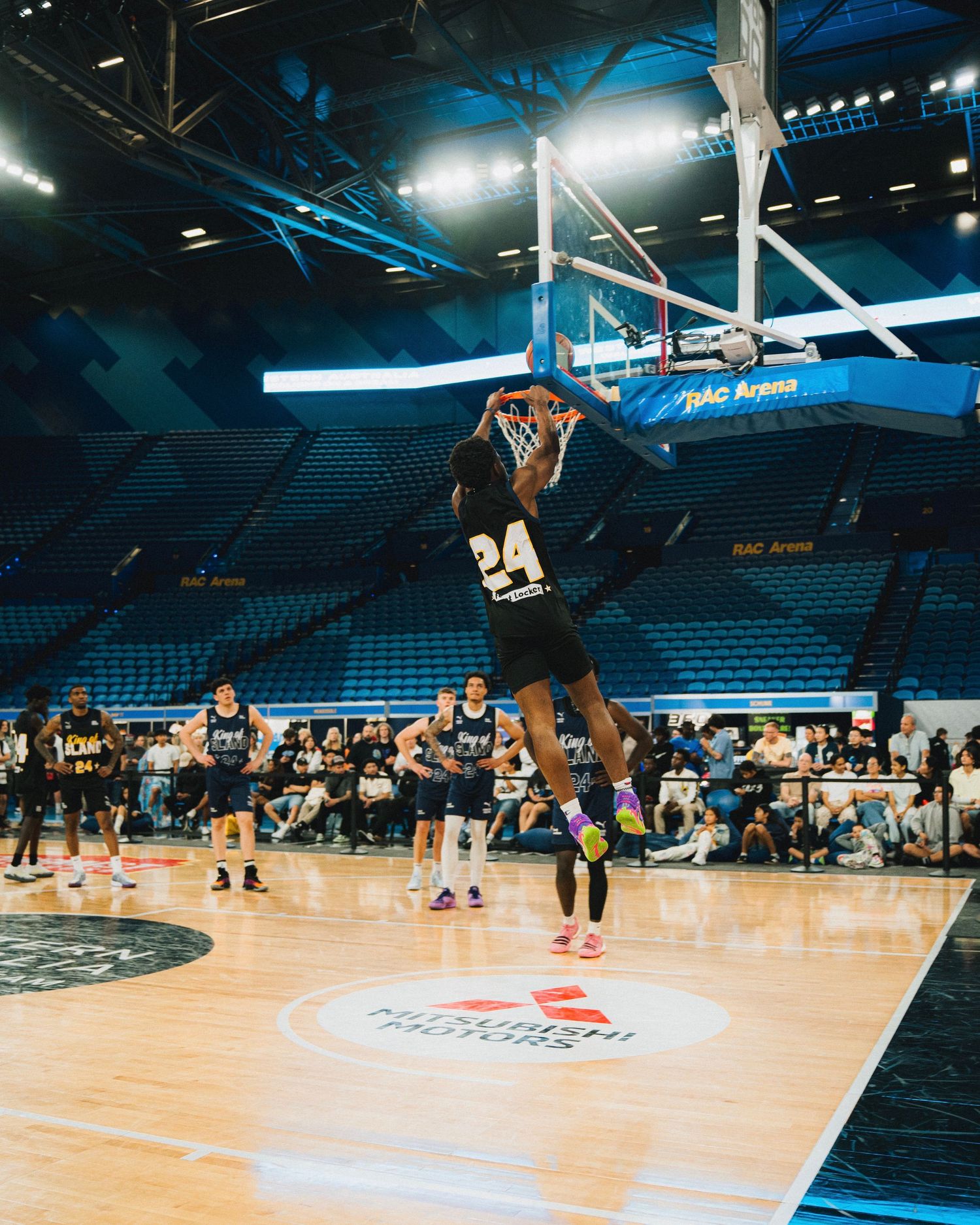 Basketball player executes a powerful dunk in a professional arena setting.
